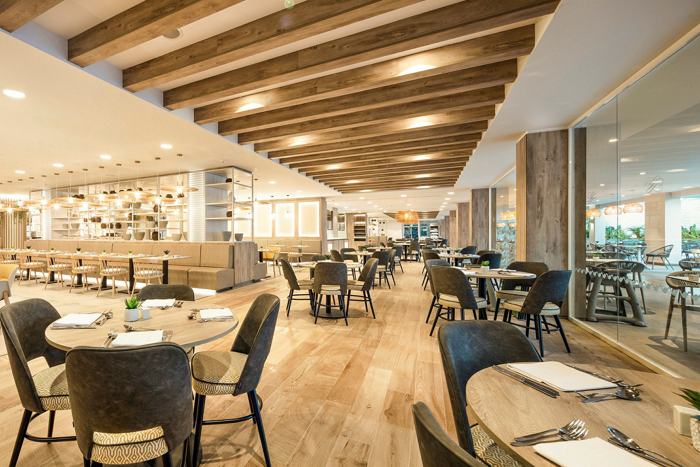 Interiør af en moderne restaurant med borde og stole, trædetaljer og belysning. (AI-genereret tekst)