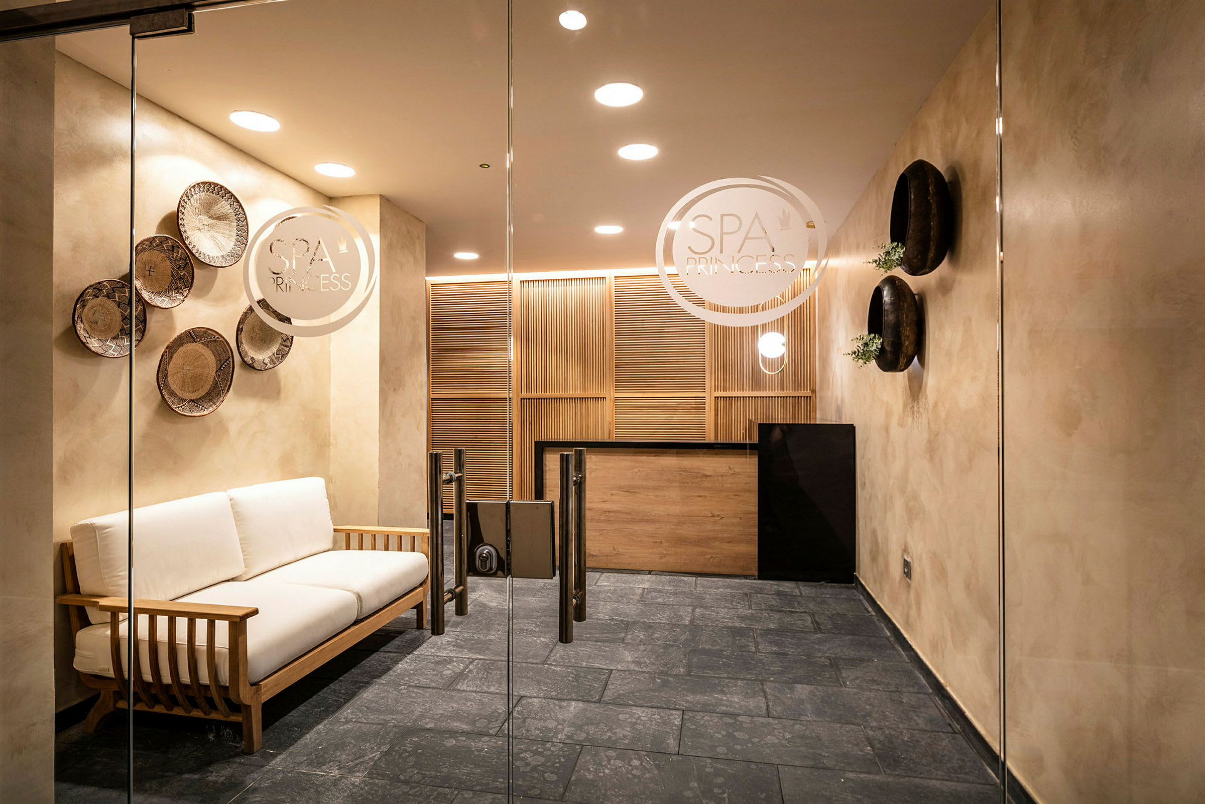 Et moderne spa-modtagelsesområde med en sofa og dekorative detaljer på væggene. (AI-genereret tekst)