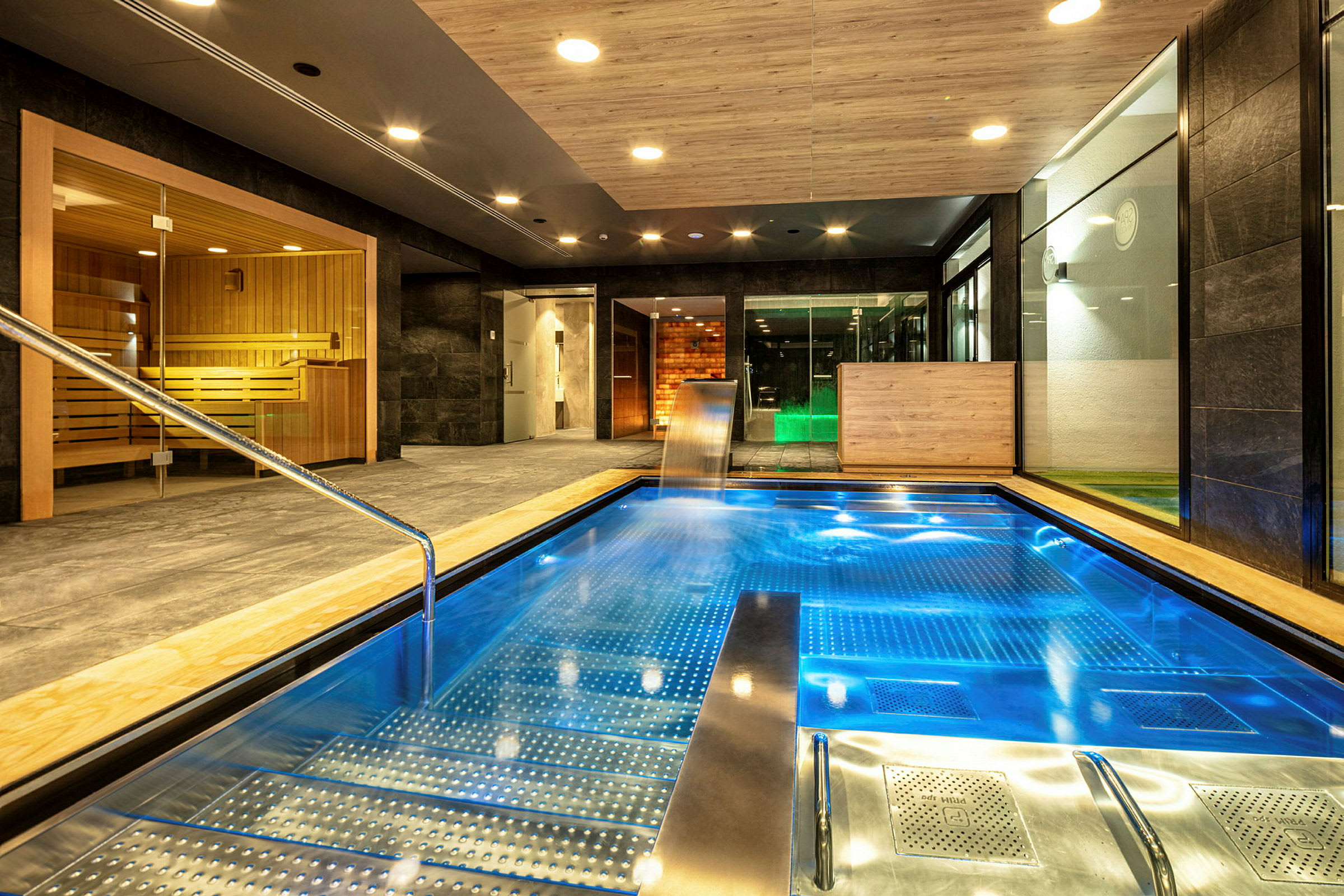 Interiør af et spa med en pool og en sauna. (AI-genereret tekst)