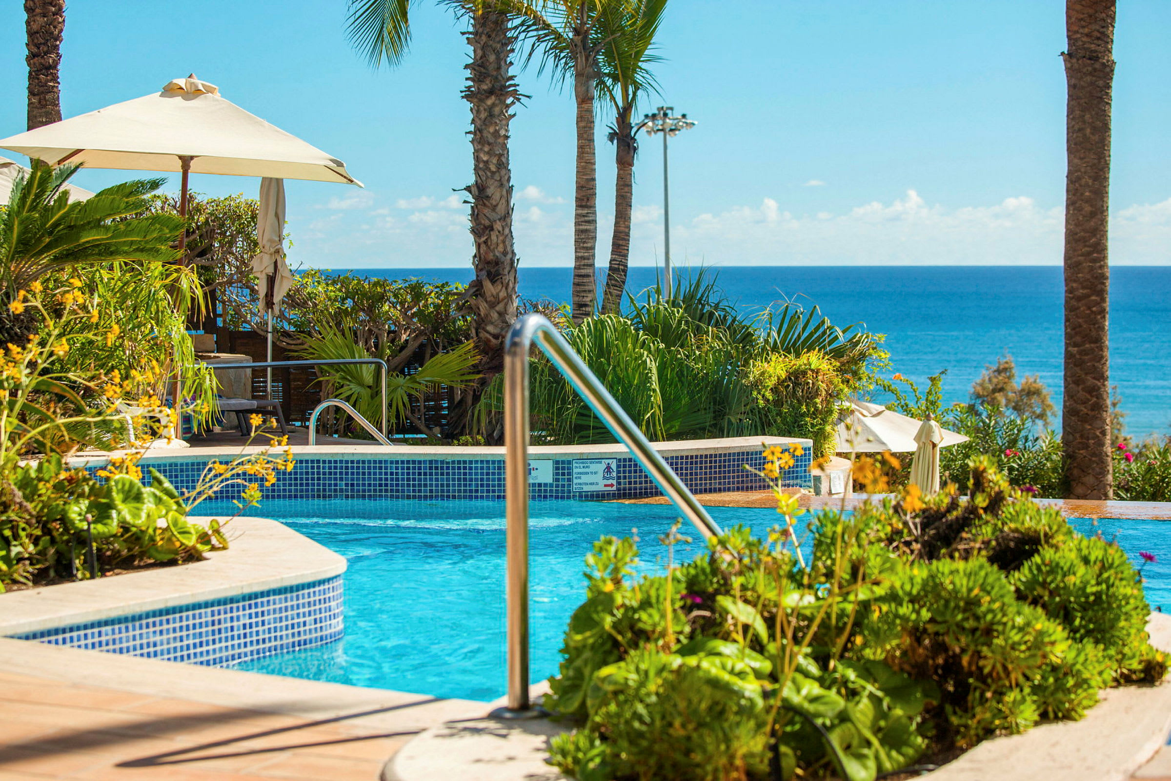 Swimmingpool ved eksotisk resort med havudsigt. (AI-genereret tekst)