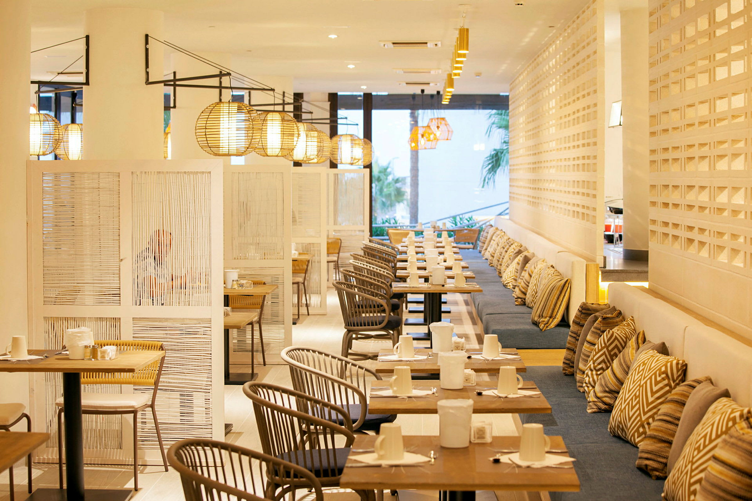 Billede af en moderne restaurant med borde, stole og lamper. (AI-genereret tekst)