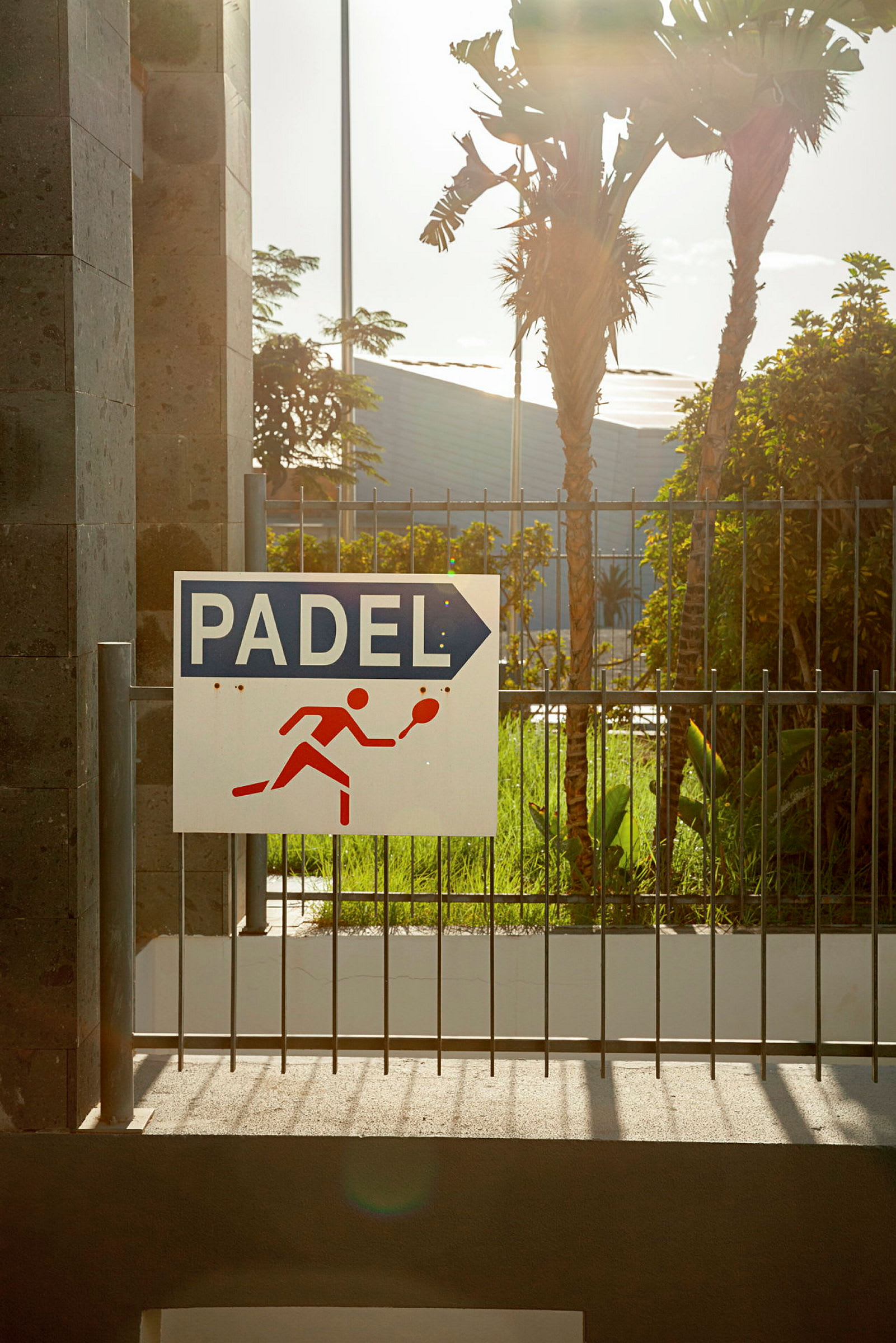 Skilt for padelbane med en illustration af en spiller. (AI-genereret tekst)