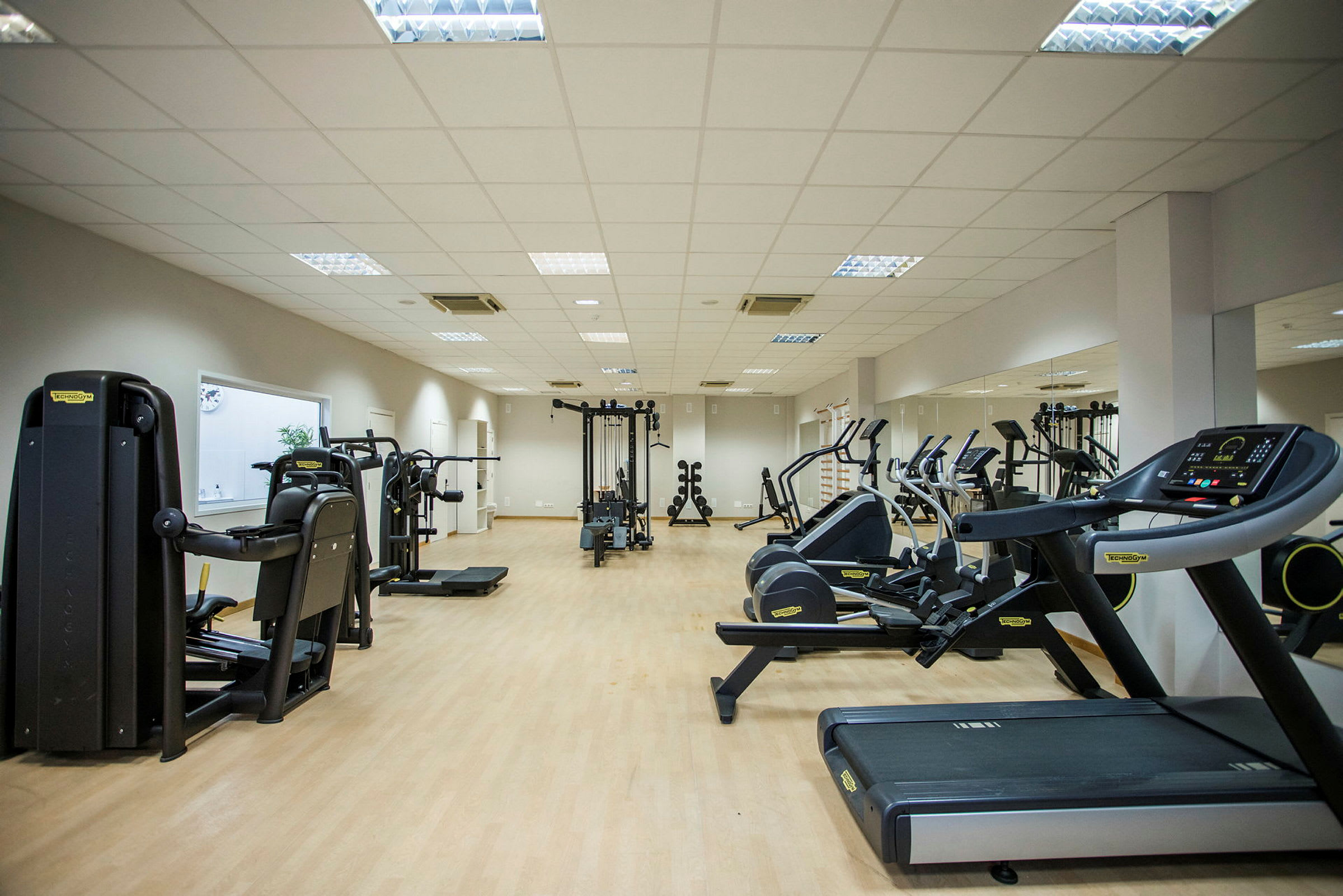 Et fitnesscenter med træningsmaskiner, løbebånd og motionscykler. (AI-genereret tekst)