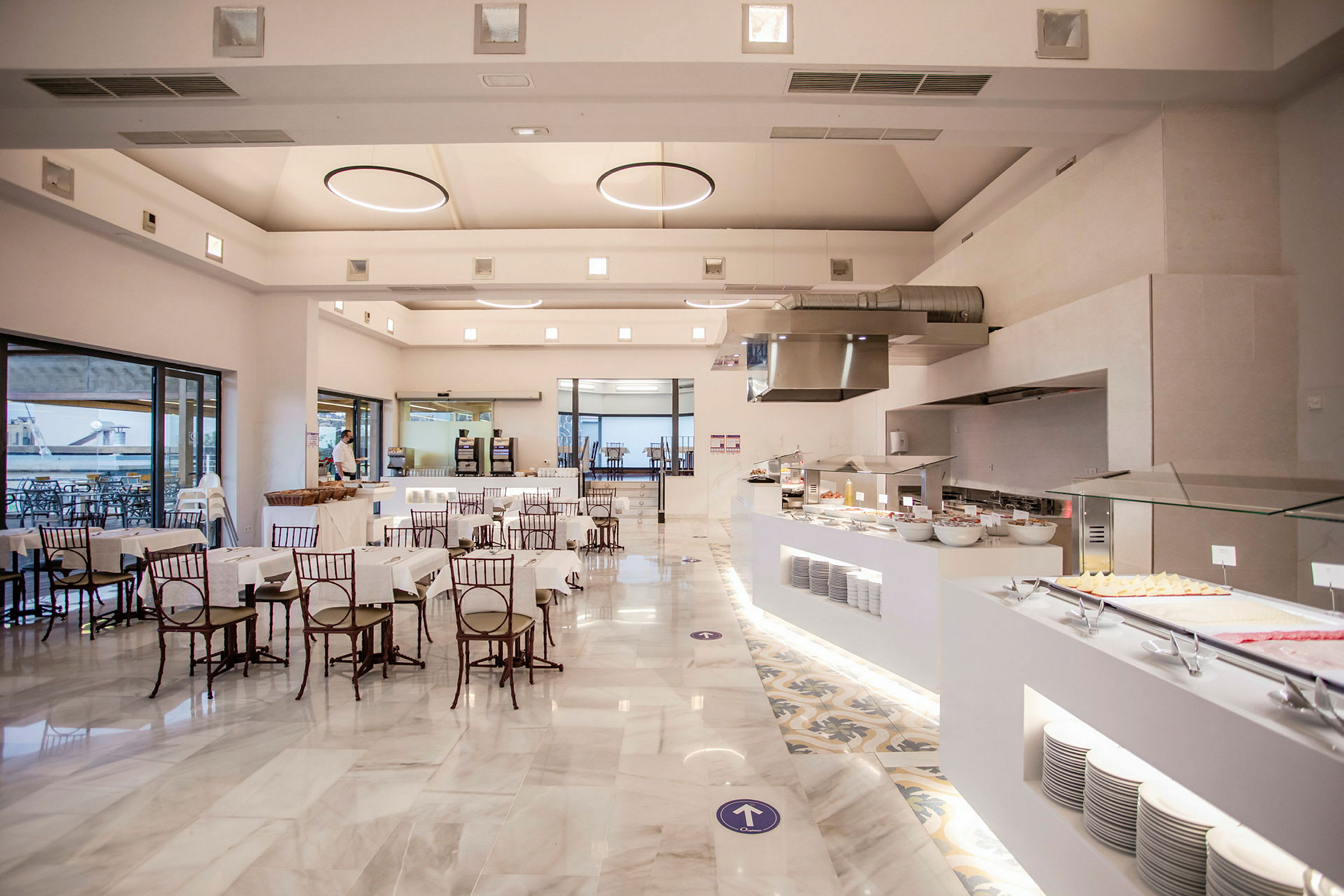 Et moderne restaurantområde med dækkede borde og en buffet på den ene side. (AI-genereret tekst)