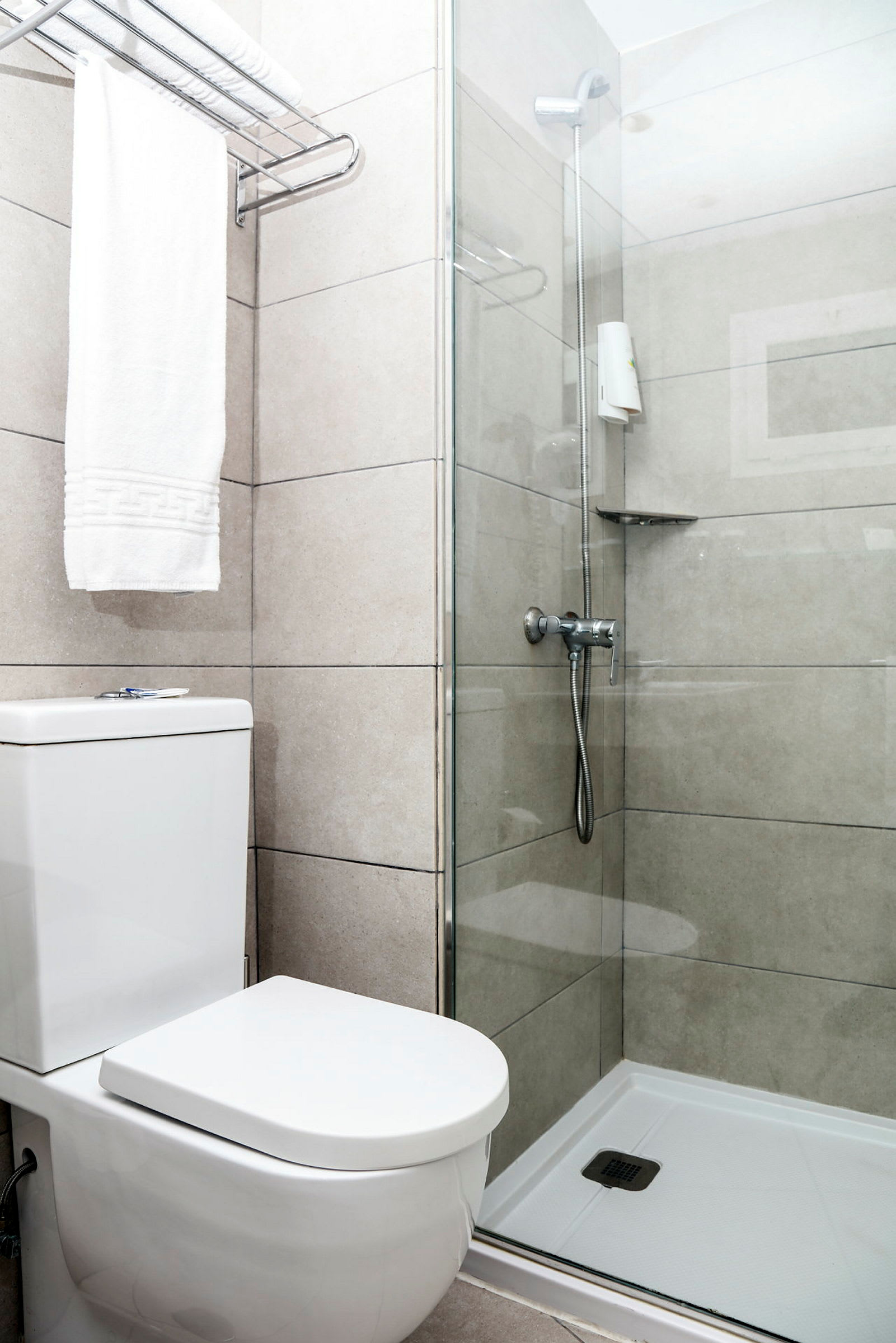 Et badeværelse med brusekabine og toilet. (AI-genereret tekst)