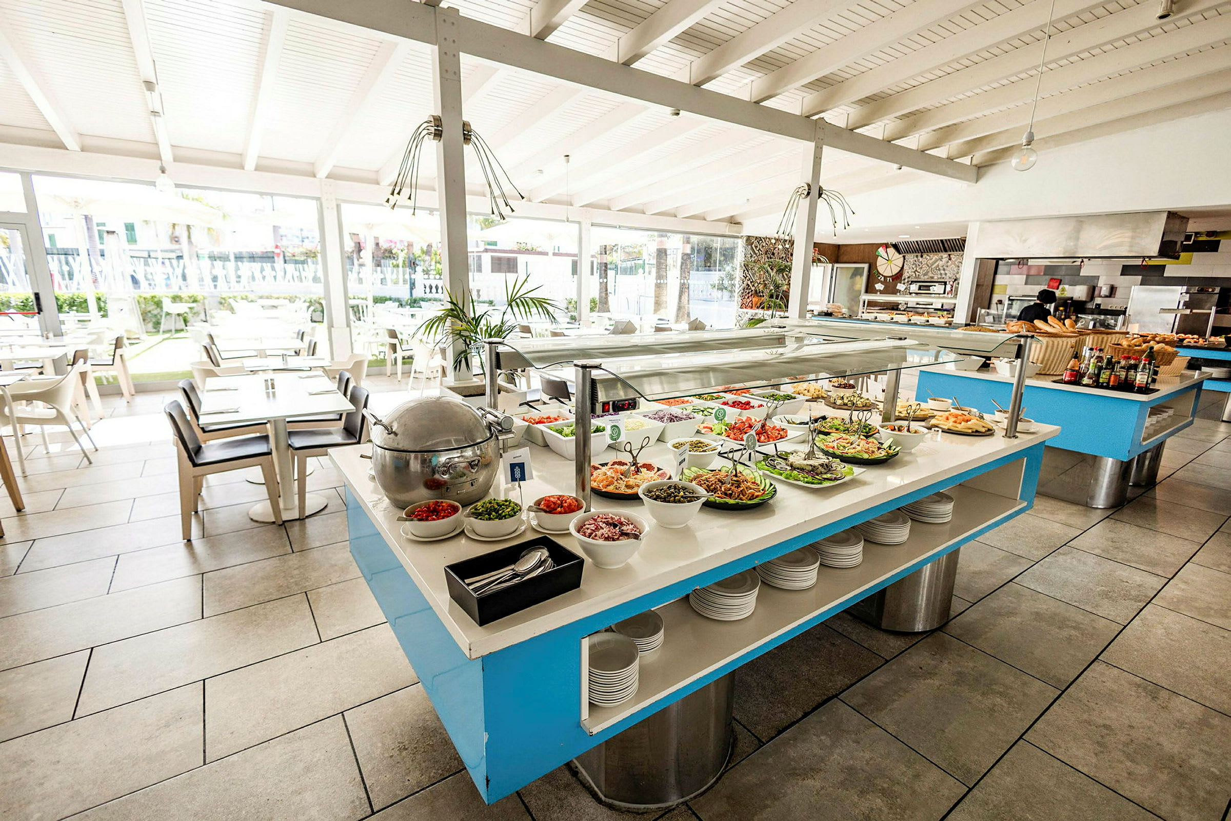 En buffet med salater og forskellige retter i en lys spisesal. (AI-genereret tekst)