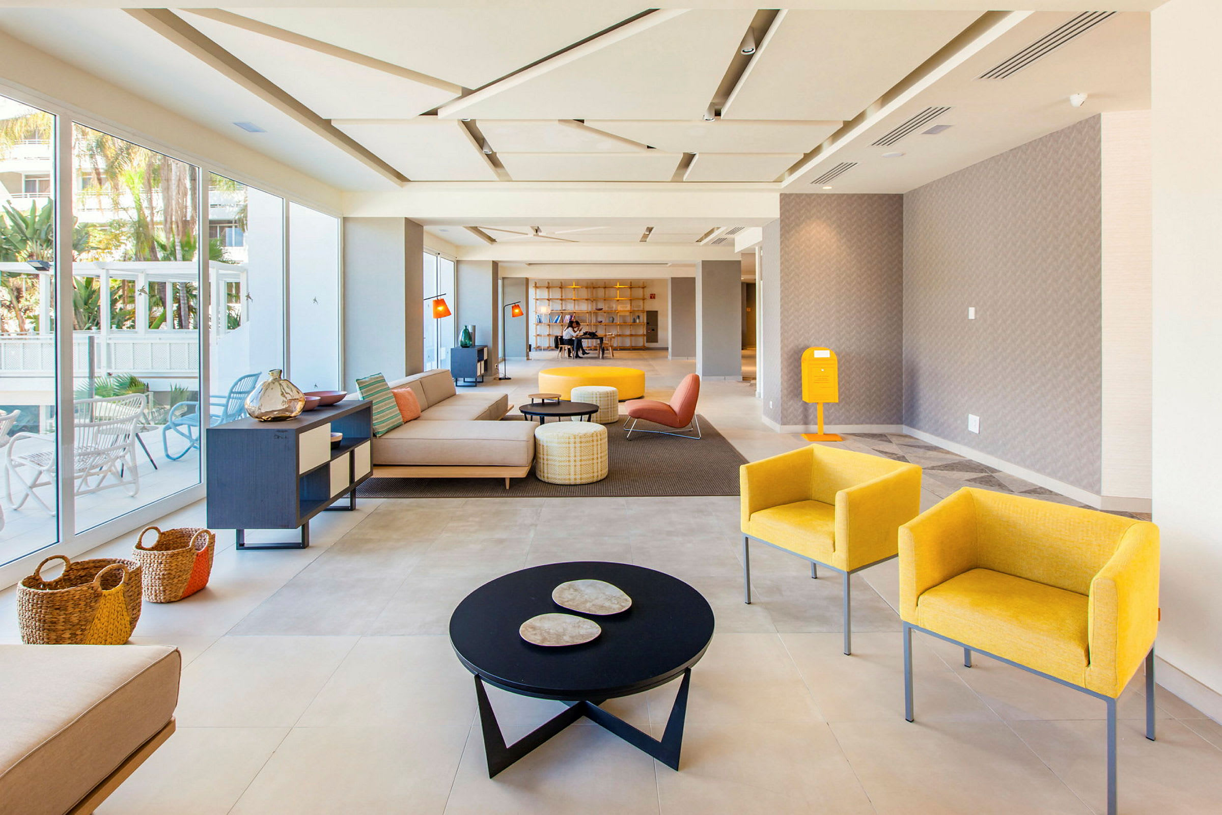 Lys og moderne hotellobby med siddeområder og glasvægge. (AI-genereret tekst)