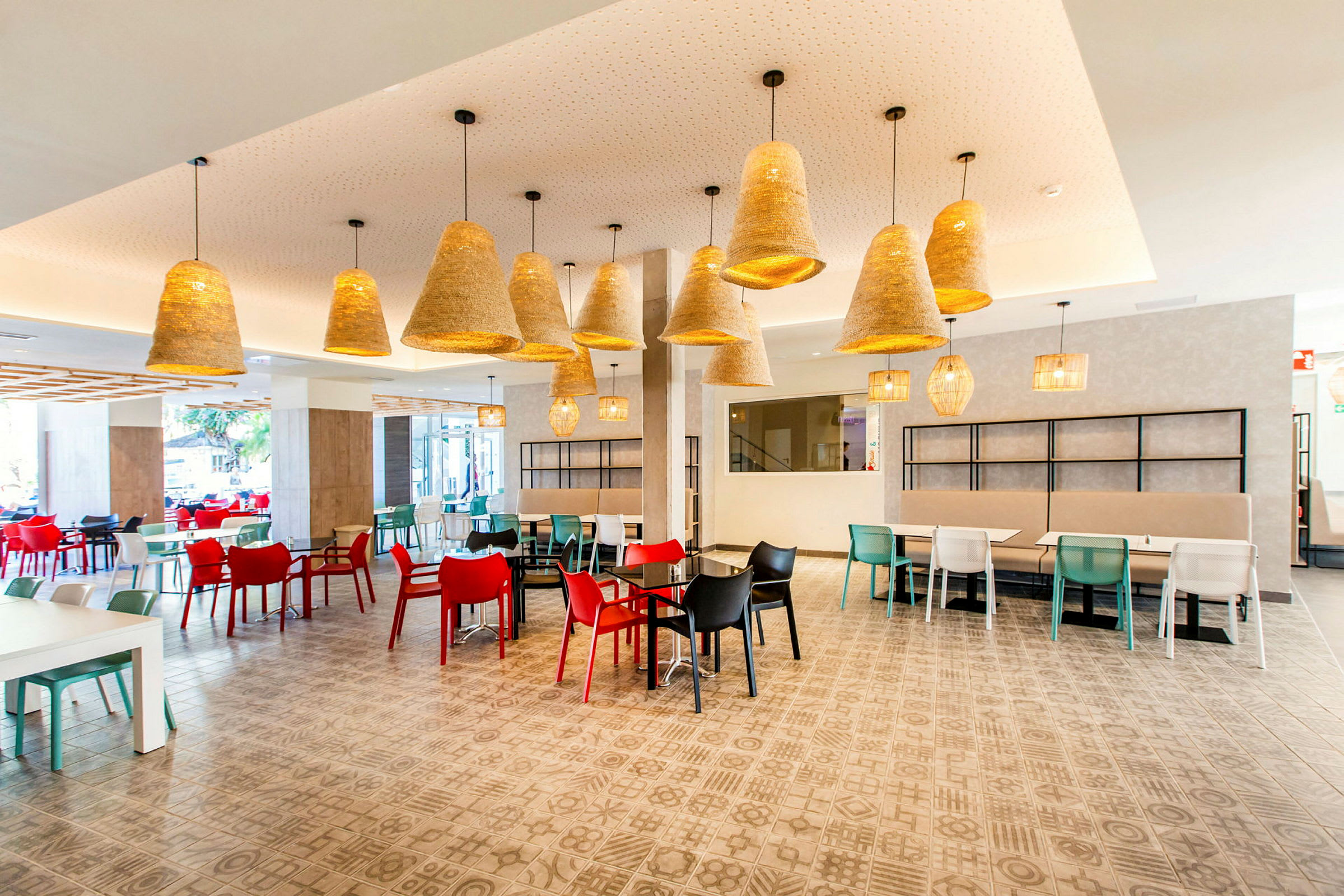 Interiør af en restaurant med farverige stole og hængende lamper. (AI-genereret tekst)
