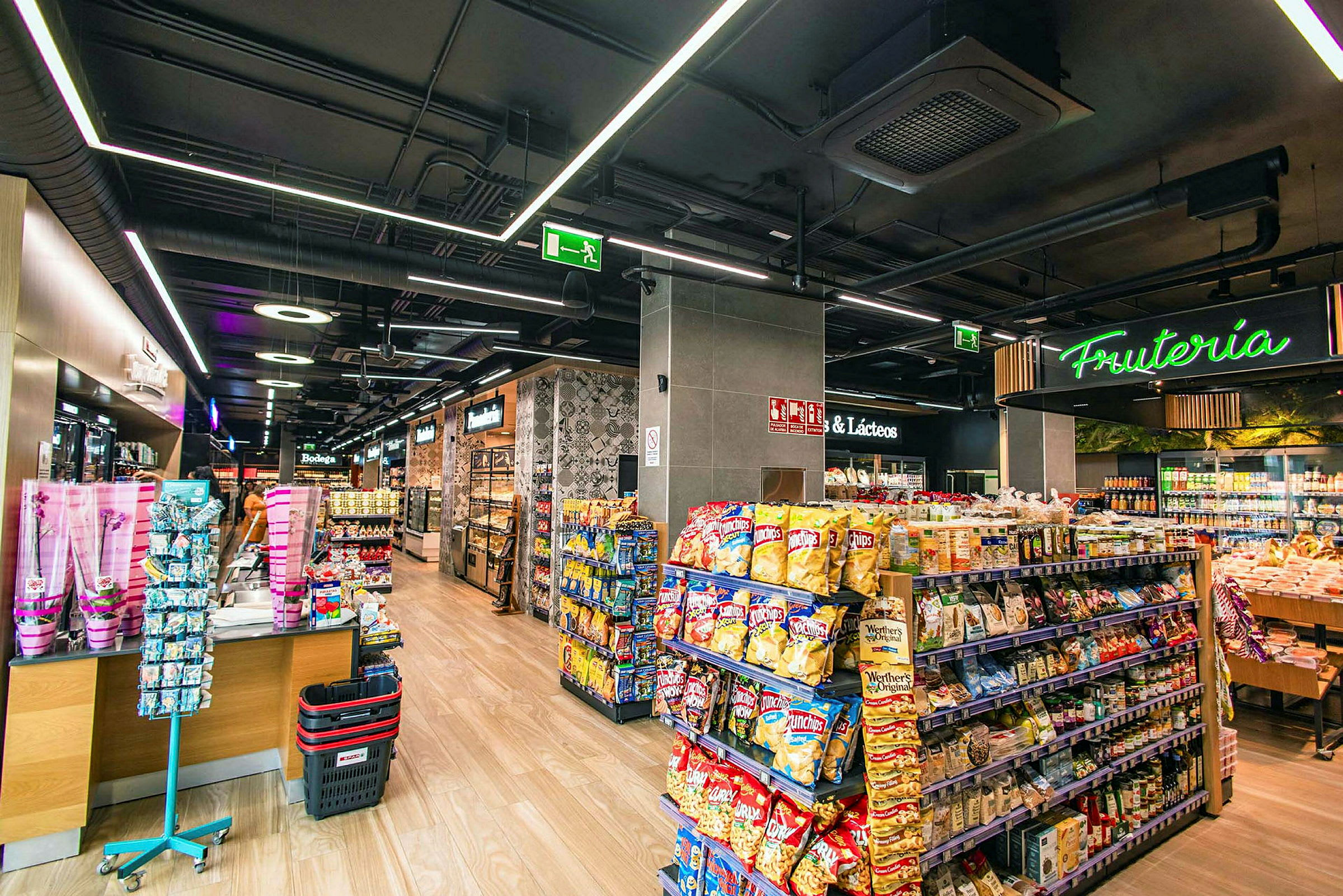 Interiør af en velbelyst butik med hylder fyldt med snacks og varer. (AI-genereret tekst)