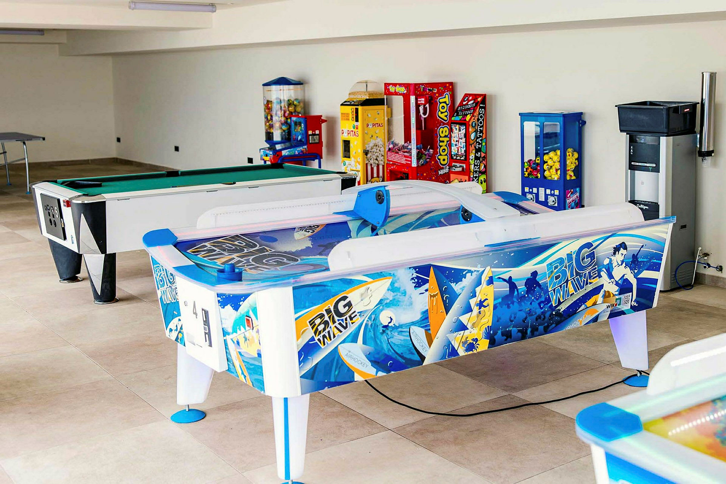 Et spillerum med billiardbord, air hockey og forskellige spilleautomater. (AI-genereret tekst)