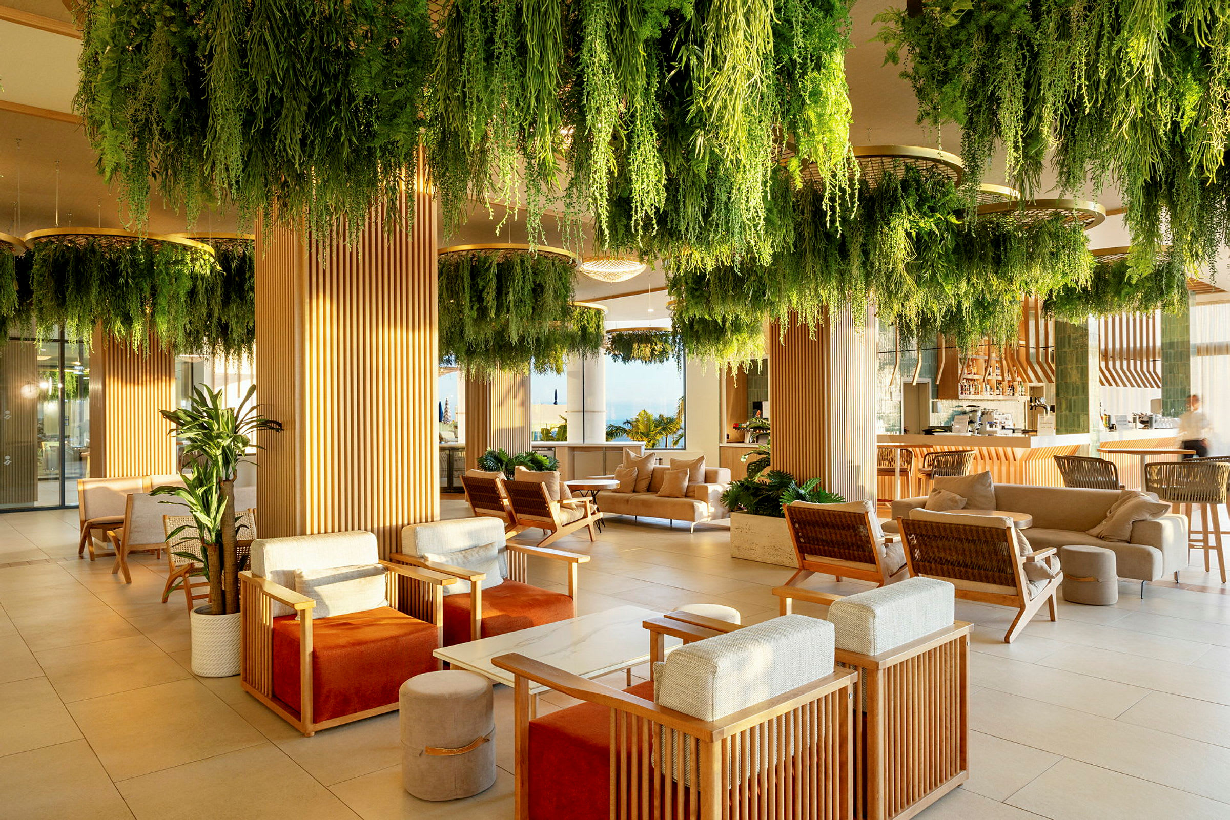 En moderne lounge med siddegrupper og grønne planter, der hænger fra loftet. (AI-genereret tekst)