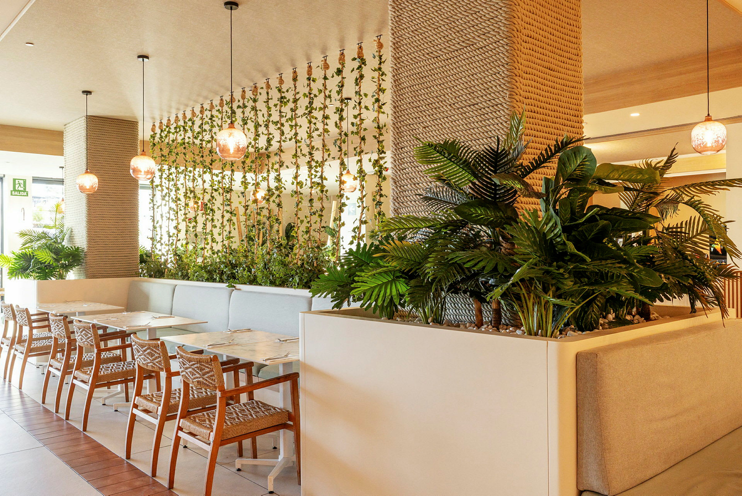 Interiør af en restaurant med vægdekorationer af planter og moderne møbler. (AI-genereret tekst)