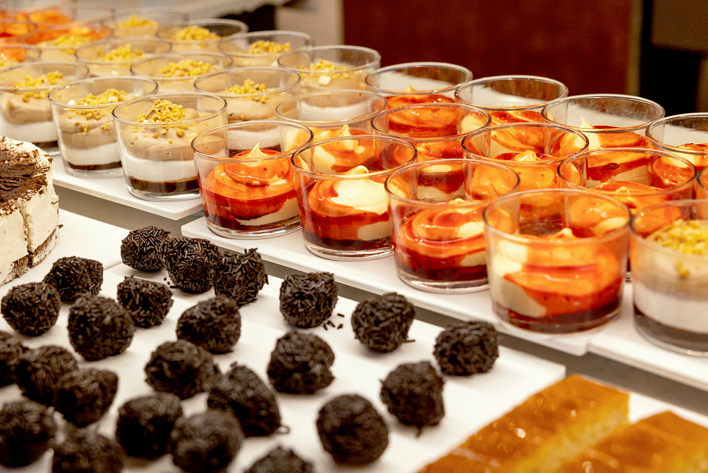 En buffet med forskellige desserter, inklusive chokoladeboller, islagkage og desserter i glas. (AI-genereret tekst)