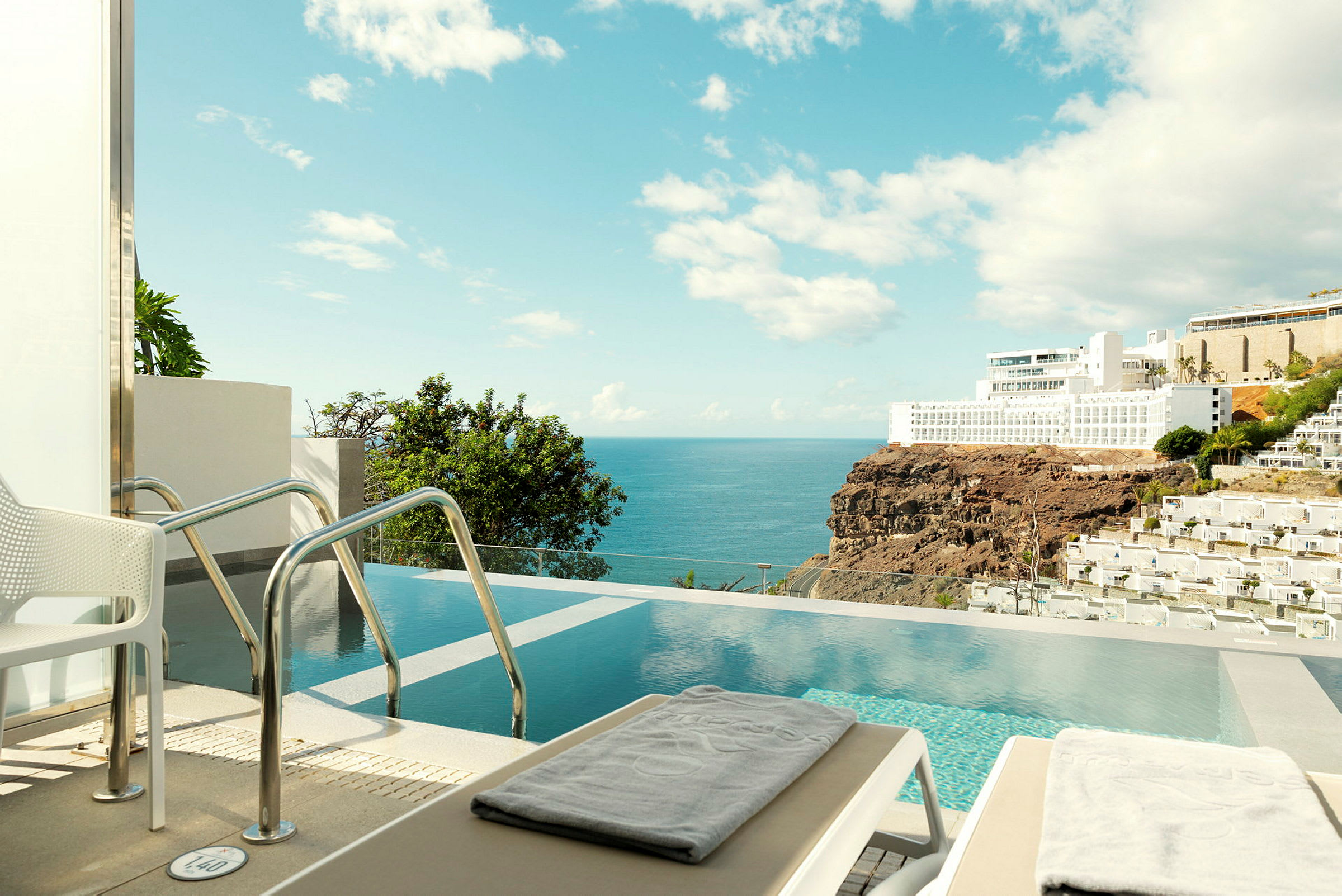 En privat pool med havudsigt og nærliggende hotellbygninger. (AI-genereret tekst)