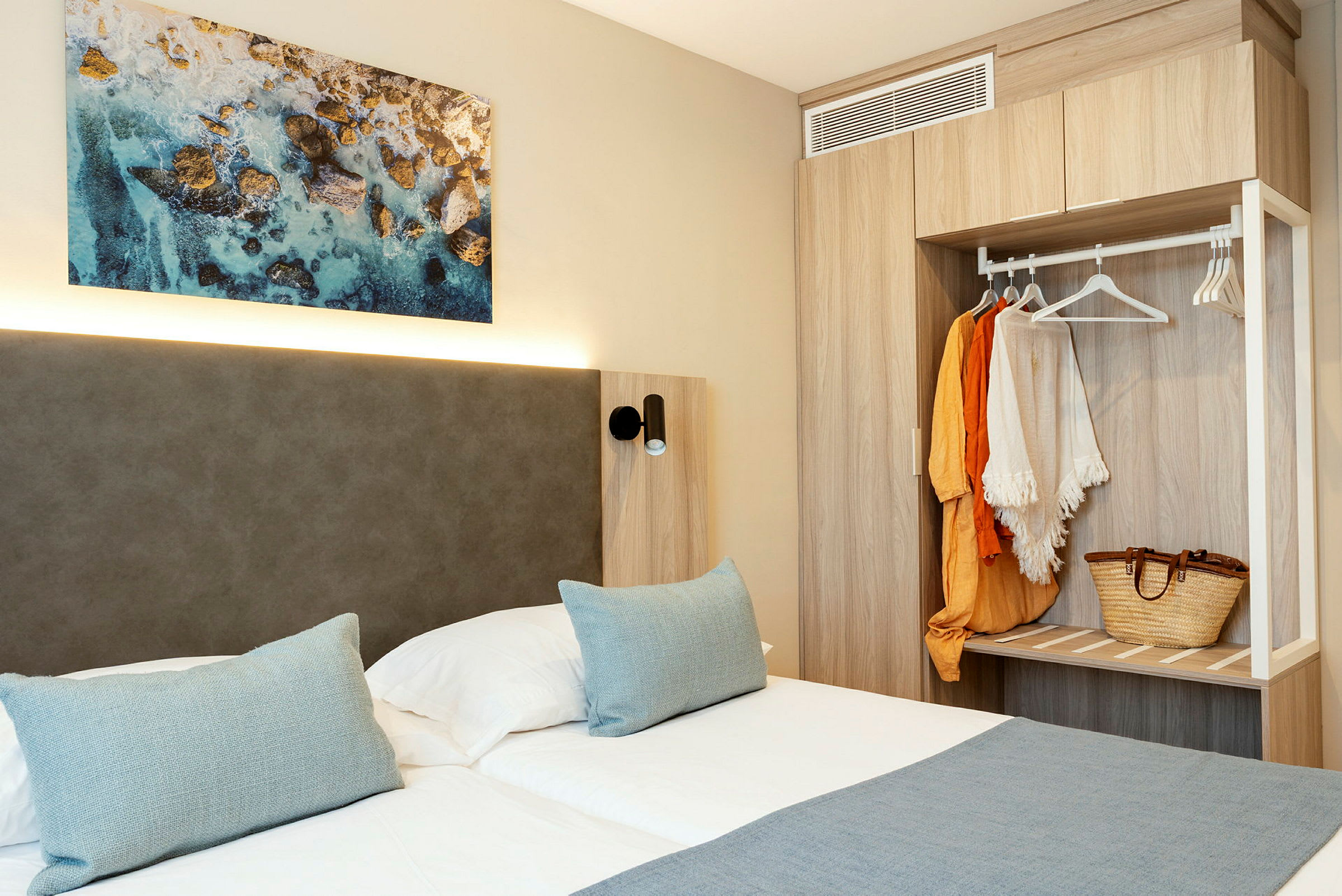 Billede af et hotelværelse med dobbeltseng, vægkunst og garderobe. (AI-genereret tekst)