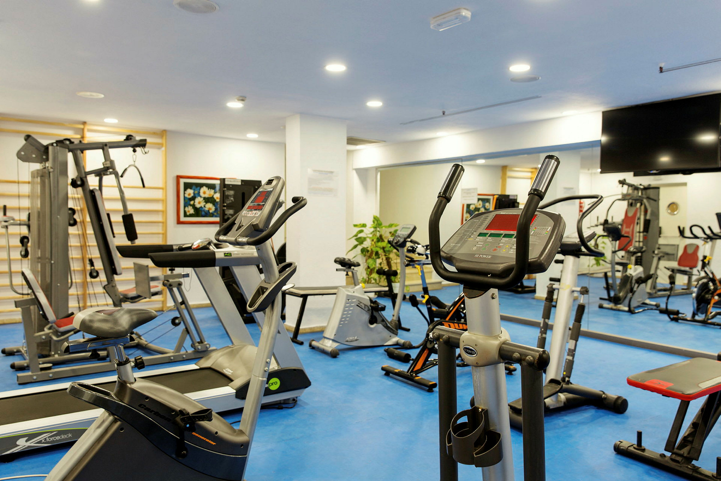 Billede af et fitnesscenter med træningsmaskiner og udstyr. (AI-genereret tekst)