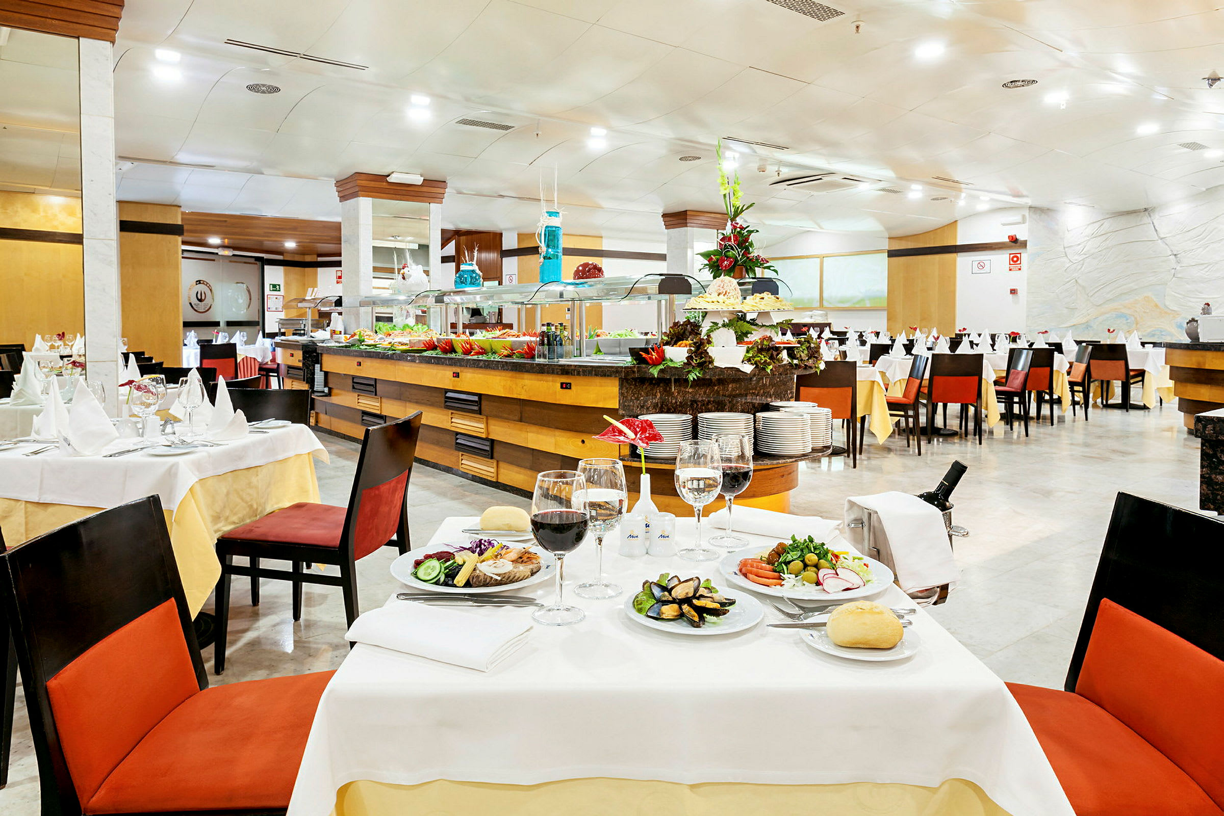 En oplyst restaurant med dækkede borde og en buffet. (AI-genereret tekst)
