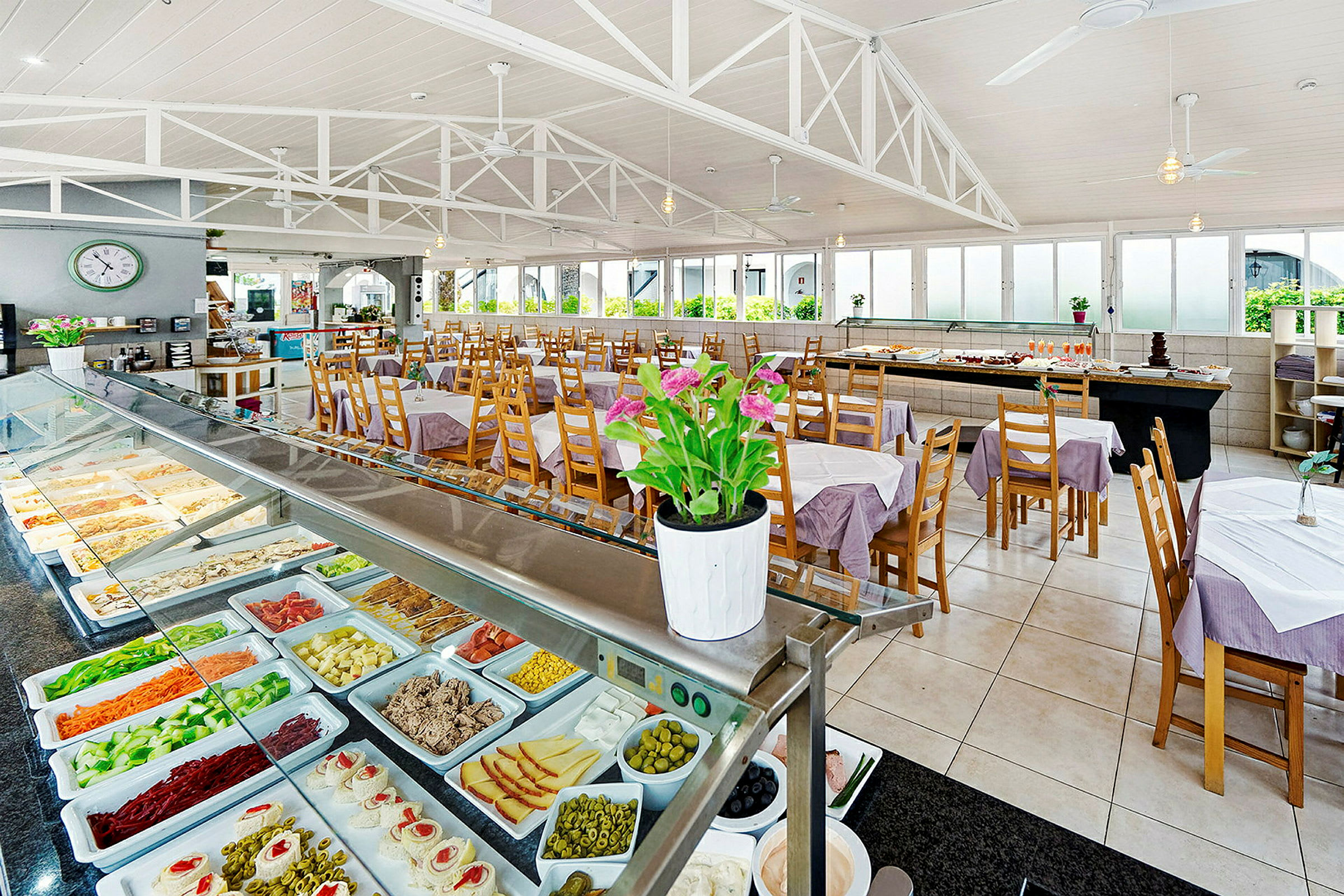 Indretning af en buffetrestaurant med anretninger og siddepladser. (AI-genereret tekst)