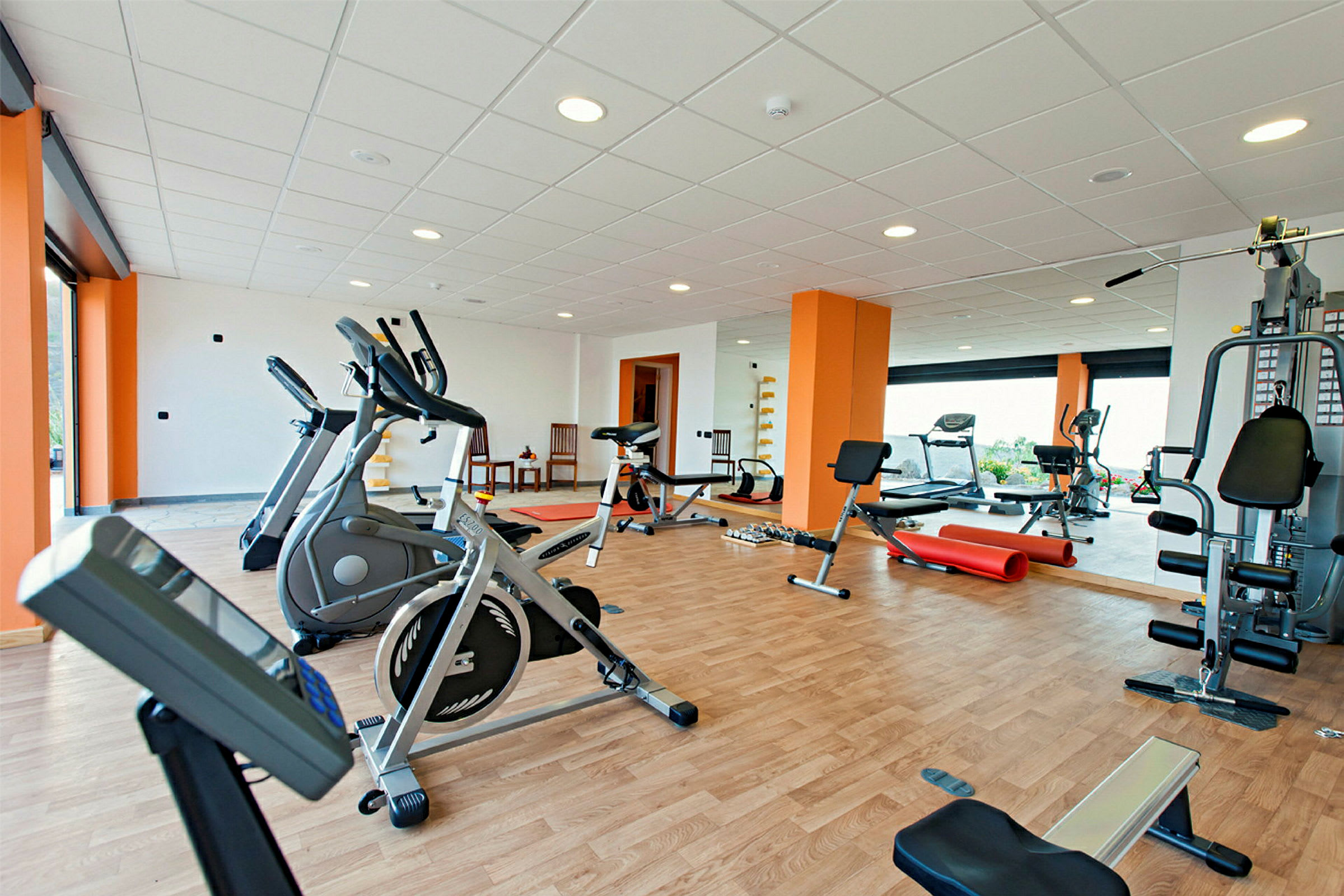 Fitnessrum med træningsmaskiner og udstyr. (AI-genereret tekst)