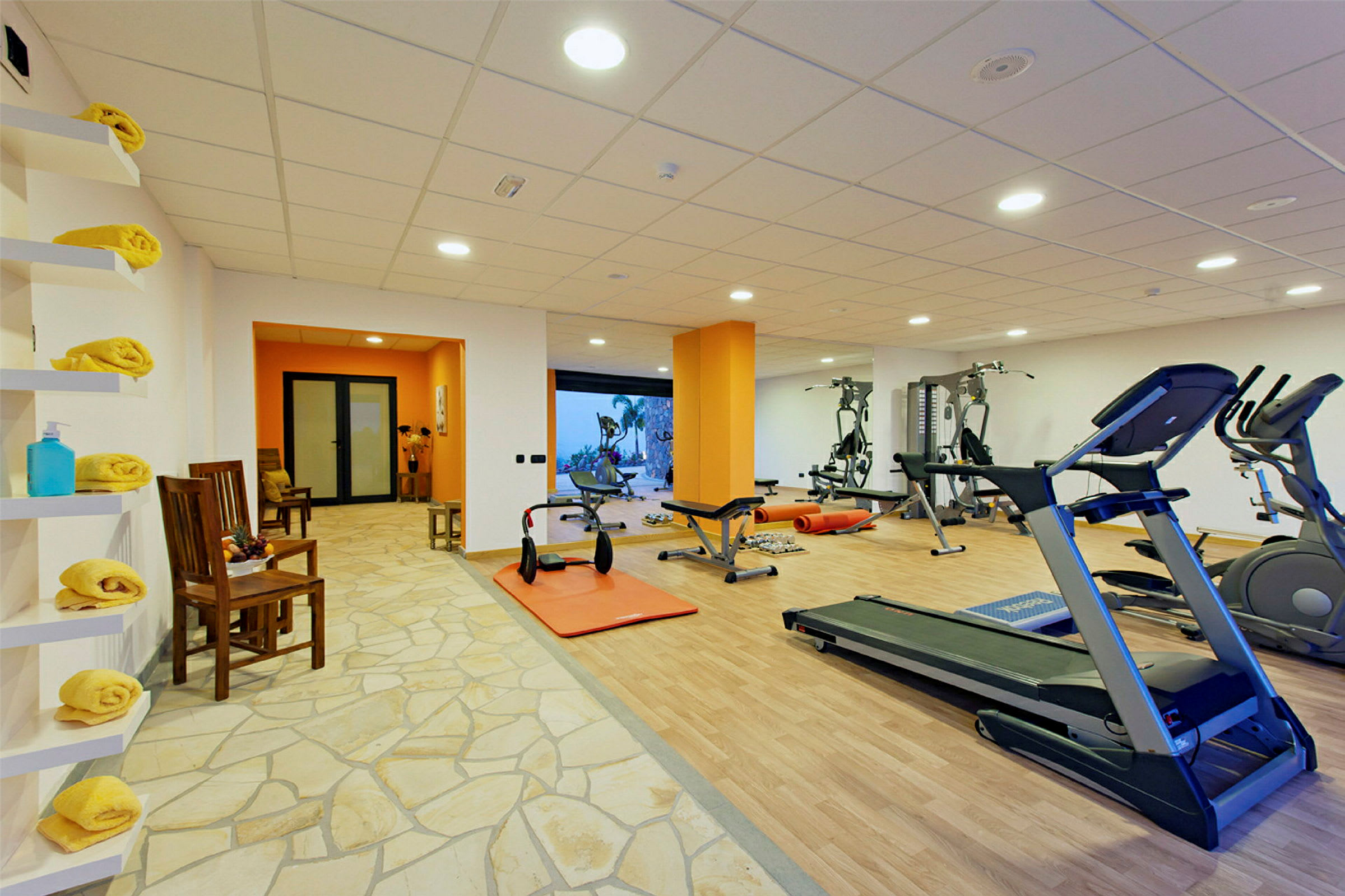 Et fitnesscenter med træningsmaskiner, løbebånd og vægte. (AI-genereret tekst)