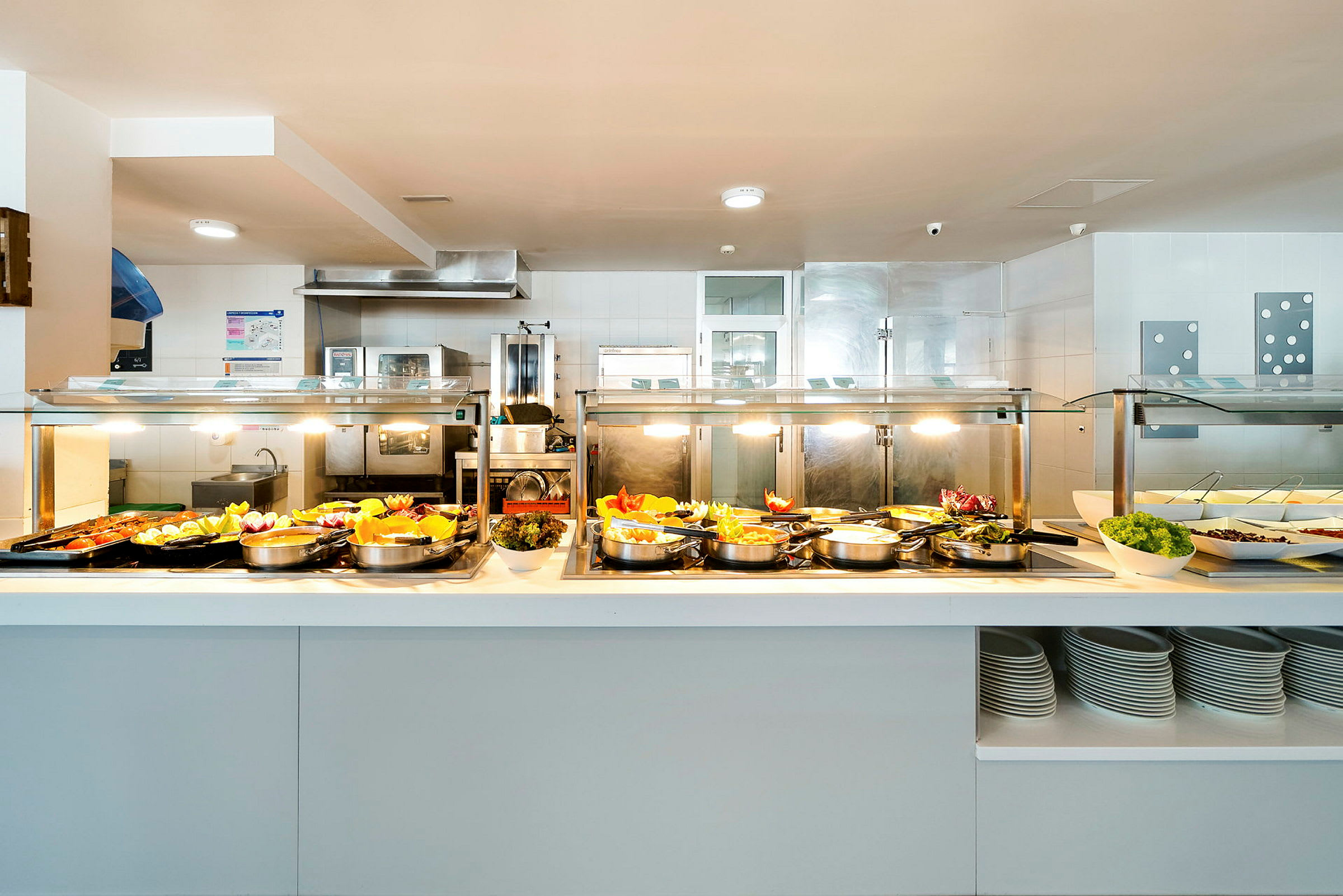 Buffetbord med forskellige retter og salater i en lys serveringsmiljø. (AI-genereret tekst)