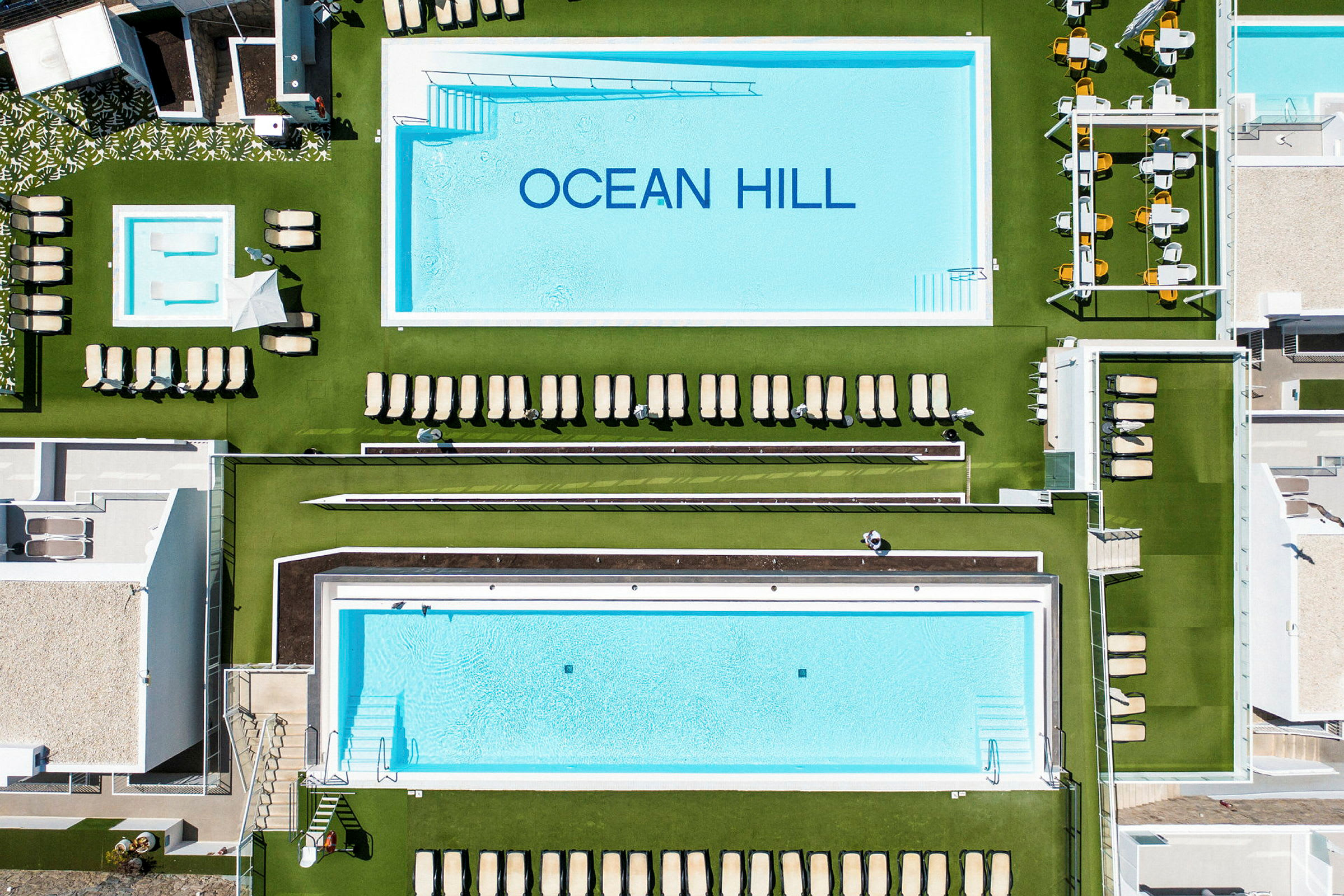 Luftbillede af poolområdet ved Ocean Hill hotellet. (AI-genereret tekst)
