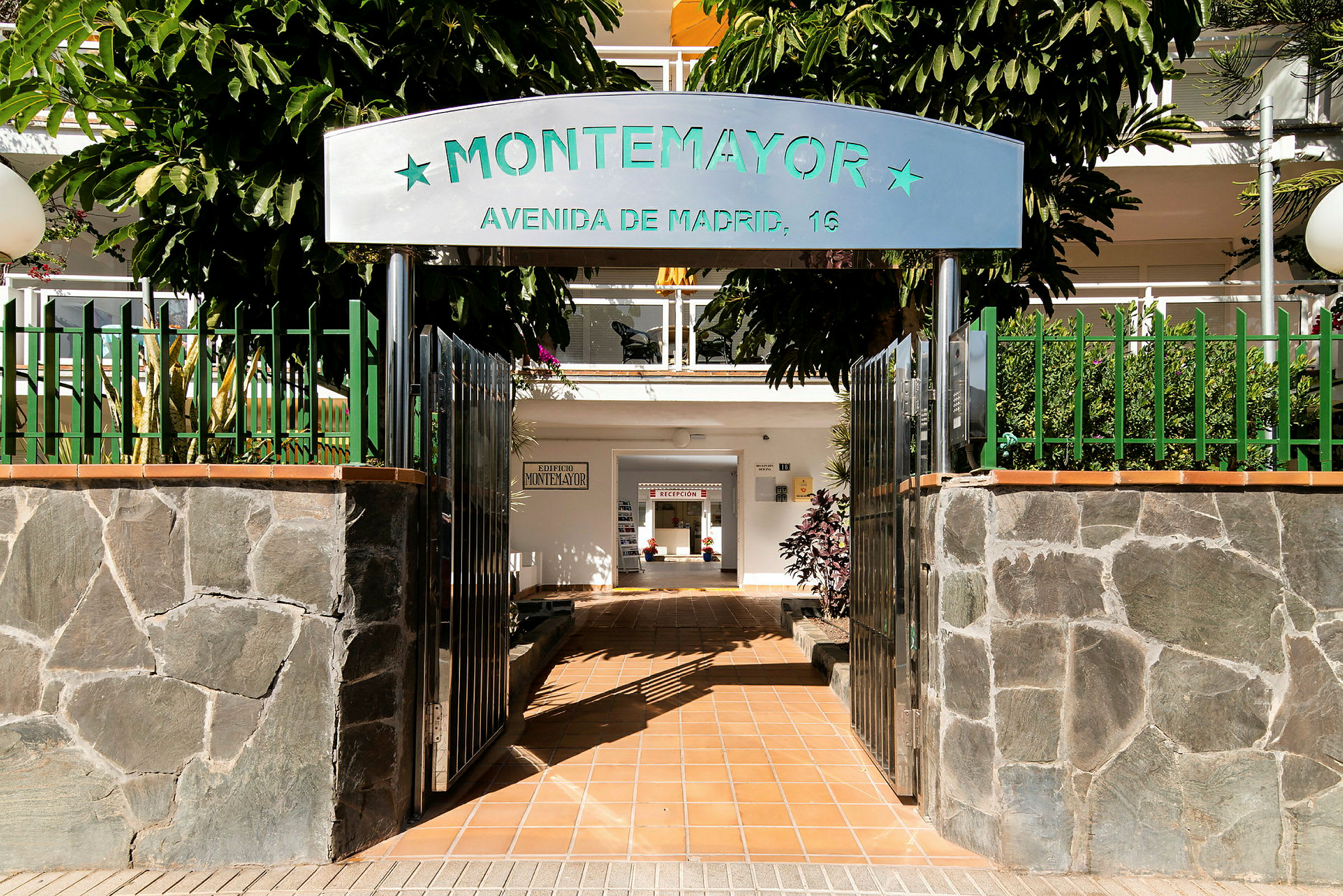 Indgang til bygning med skiltet 'Montemayor' og en indendørs gangsti. (AI-genereret tekst)