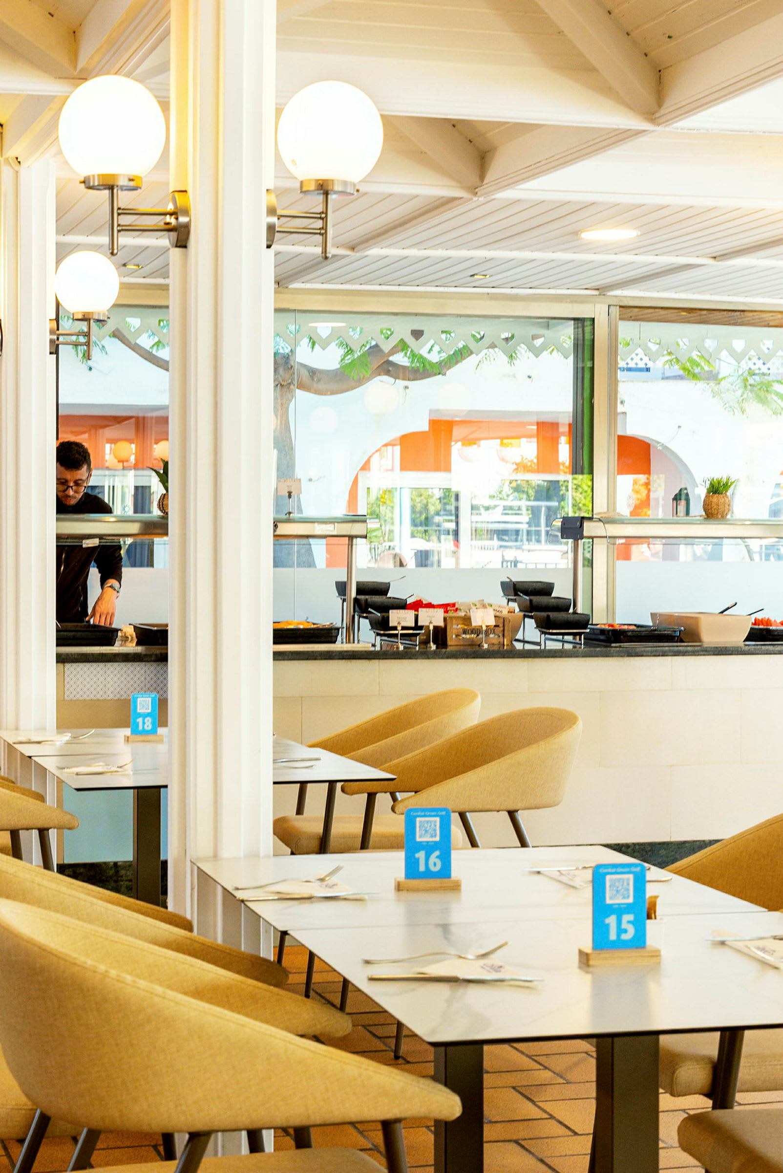 Interiør af en restaurant med borde og stole, dekoreret med lyse farver. (AI-genereret tekst)