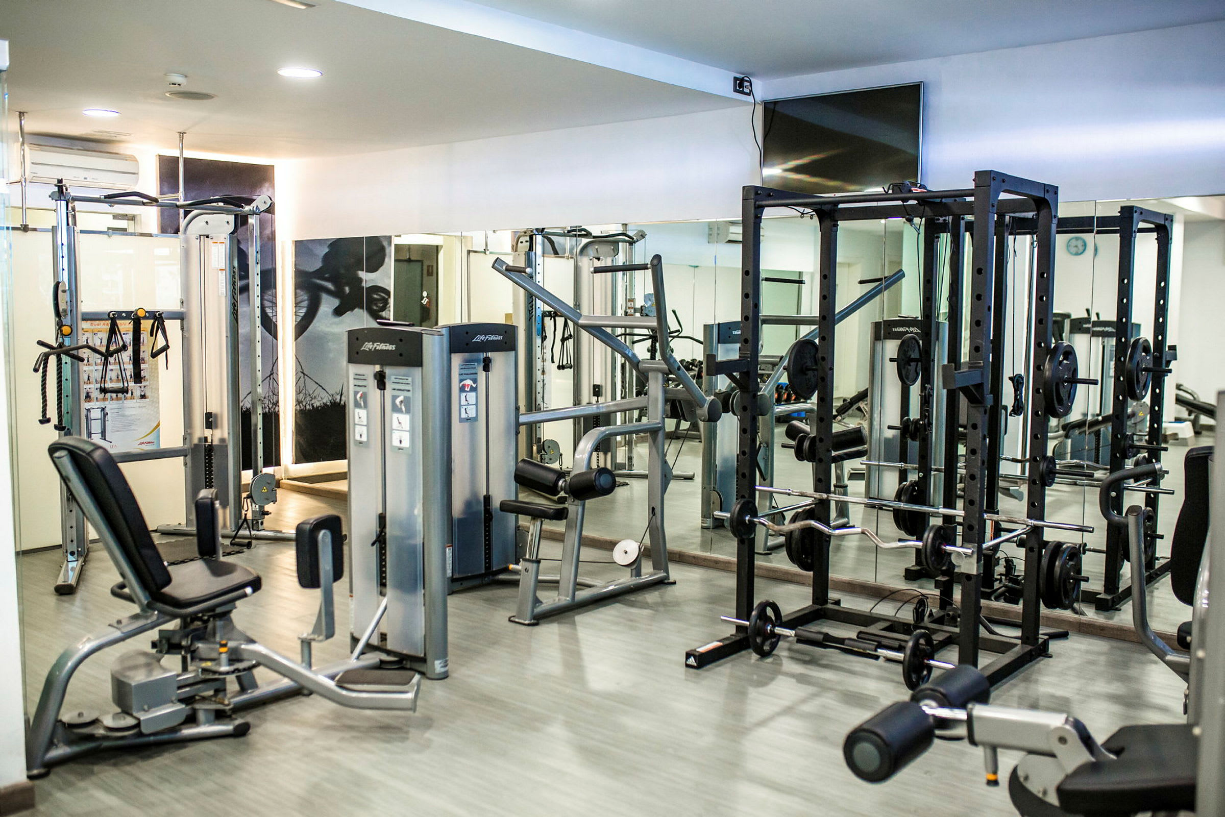 Fitnessudstyr og træningsmaskiner i et moderne træningsrum. (AI-genereret tekst)