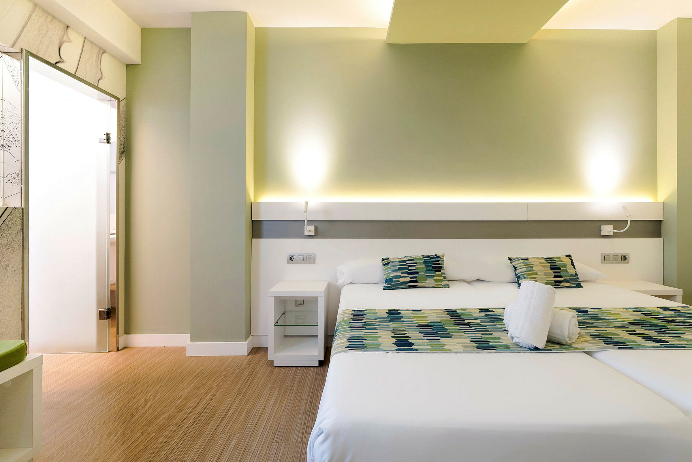 Moderne hotelværelse med to enkeltsenge og siddegruppe. (AI-genereret tekst)