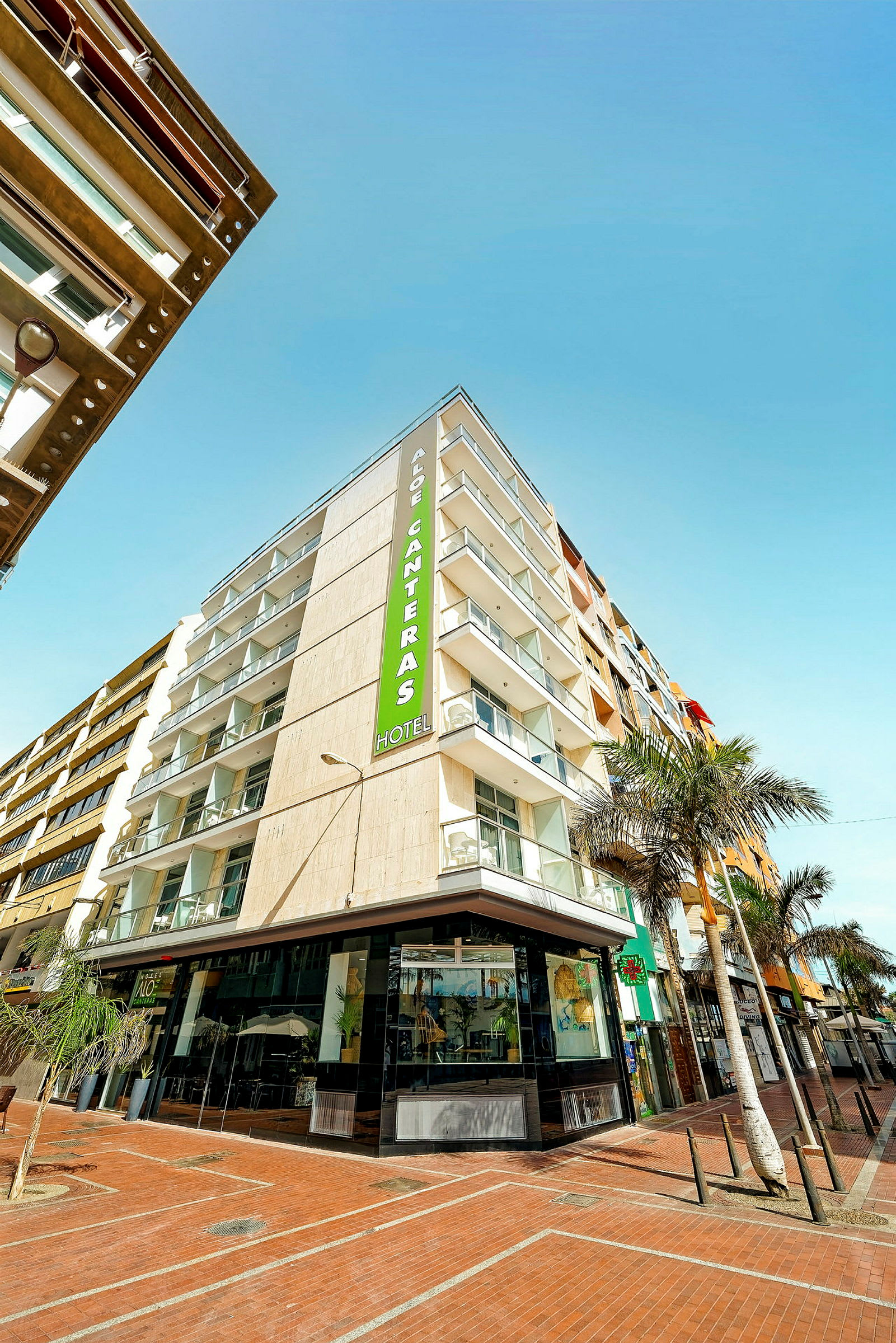 Et moderne hotel med altaner og et skilt, der viser navnet Aloe Canteras. (AI-genereret tekst)