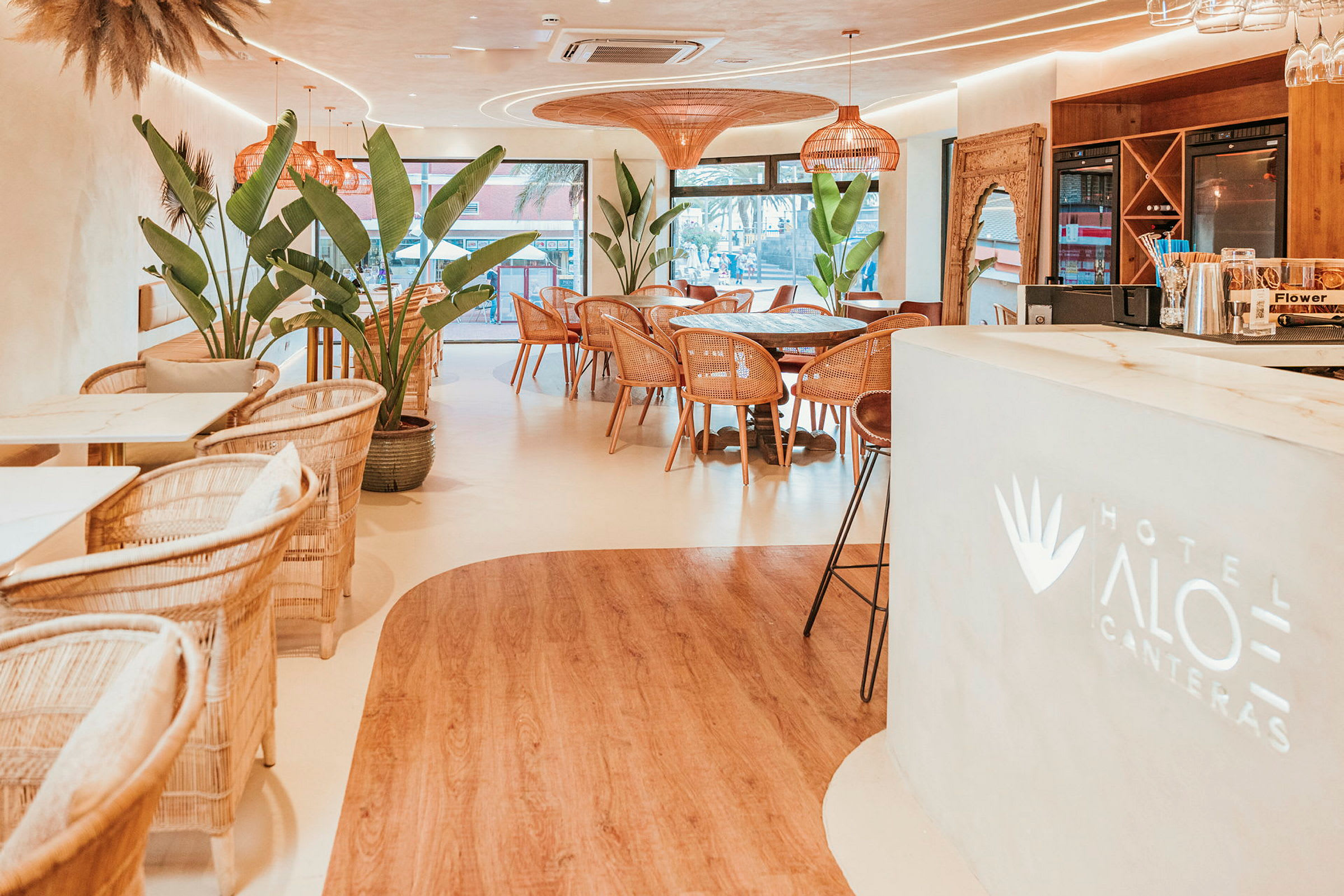 Hotelrestaurant med moderne indretning og store planter. (AI-genereret tekst)