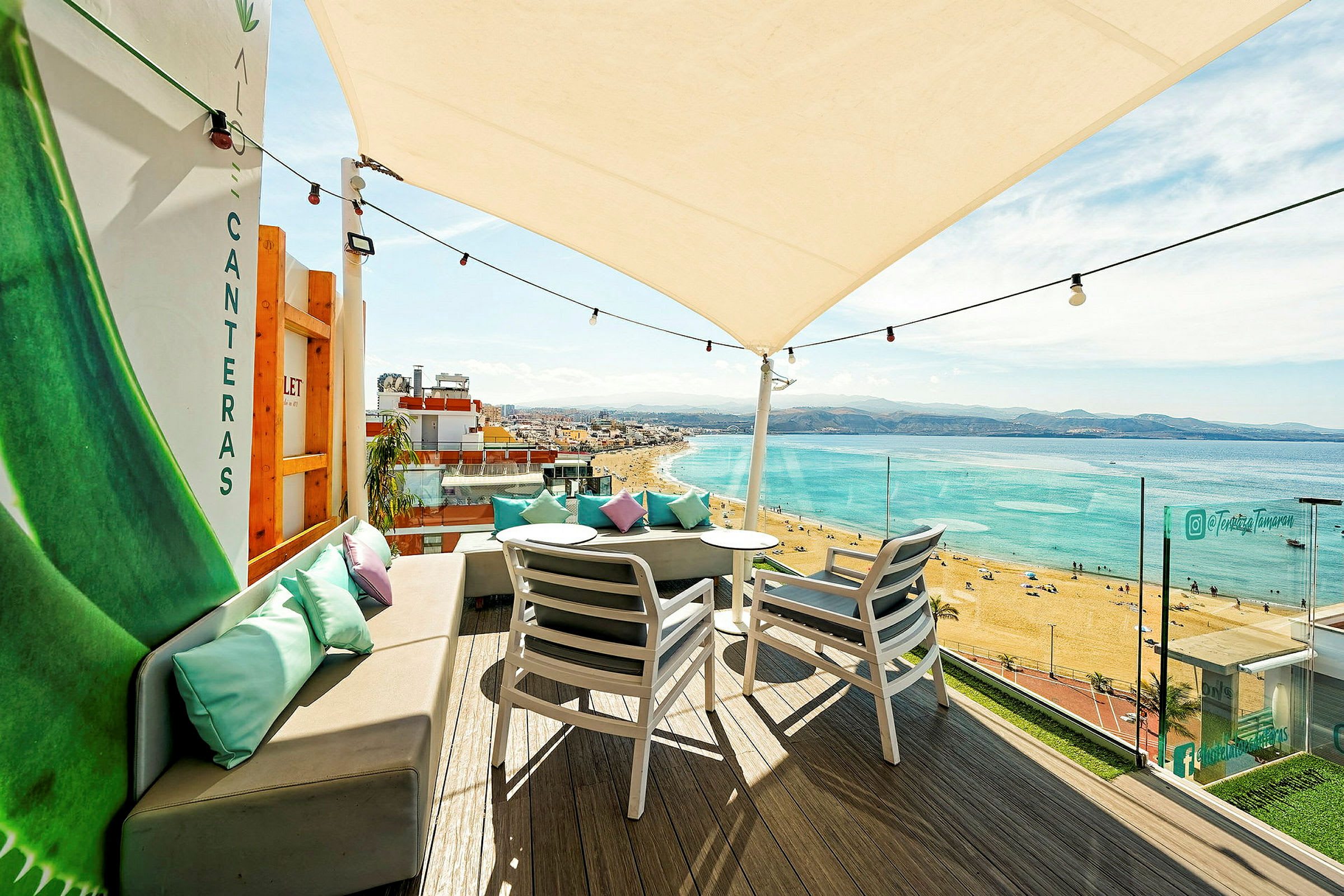 Terrasse med siddepladser og udsigt til stranden og havet. (AI-genereret tekst)