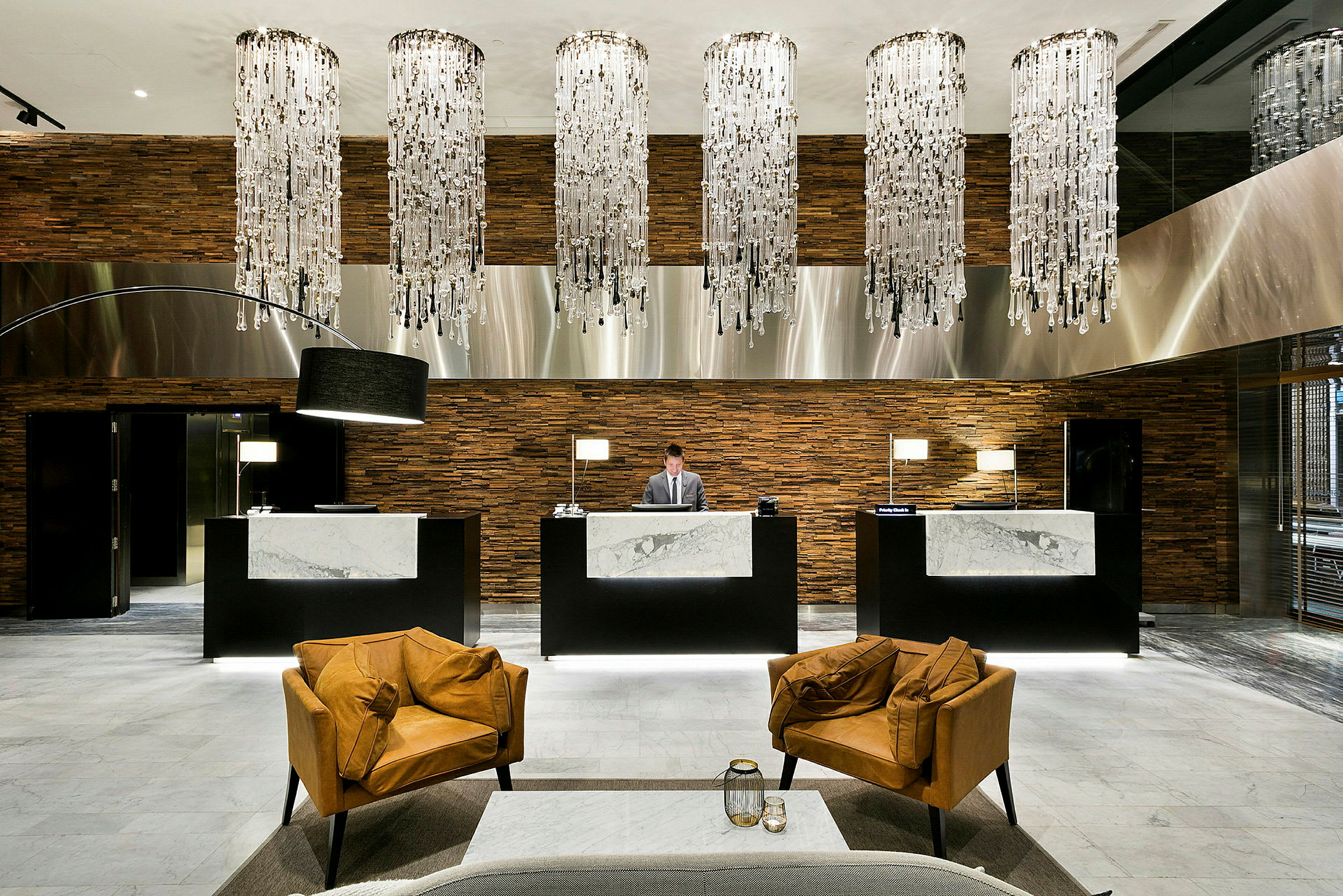 Reception i et luksuriøst hotelmiljø med elegant indretning og lysekroner. (AI-genereret tekst)