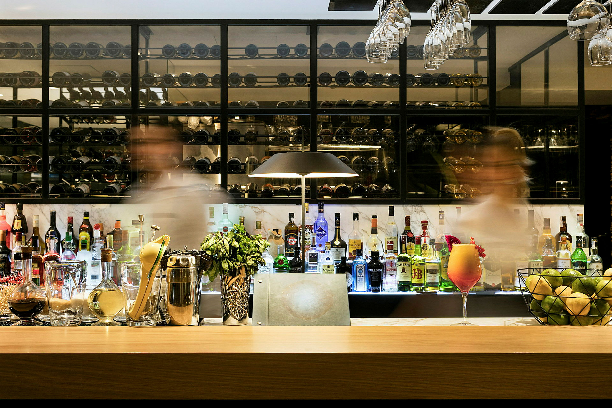 En elegant bar fyldt med forskellige spiritusflasker og tilbehør. (AI-genereret tekst)