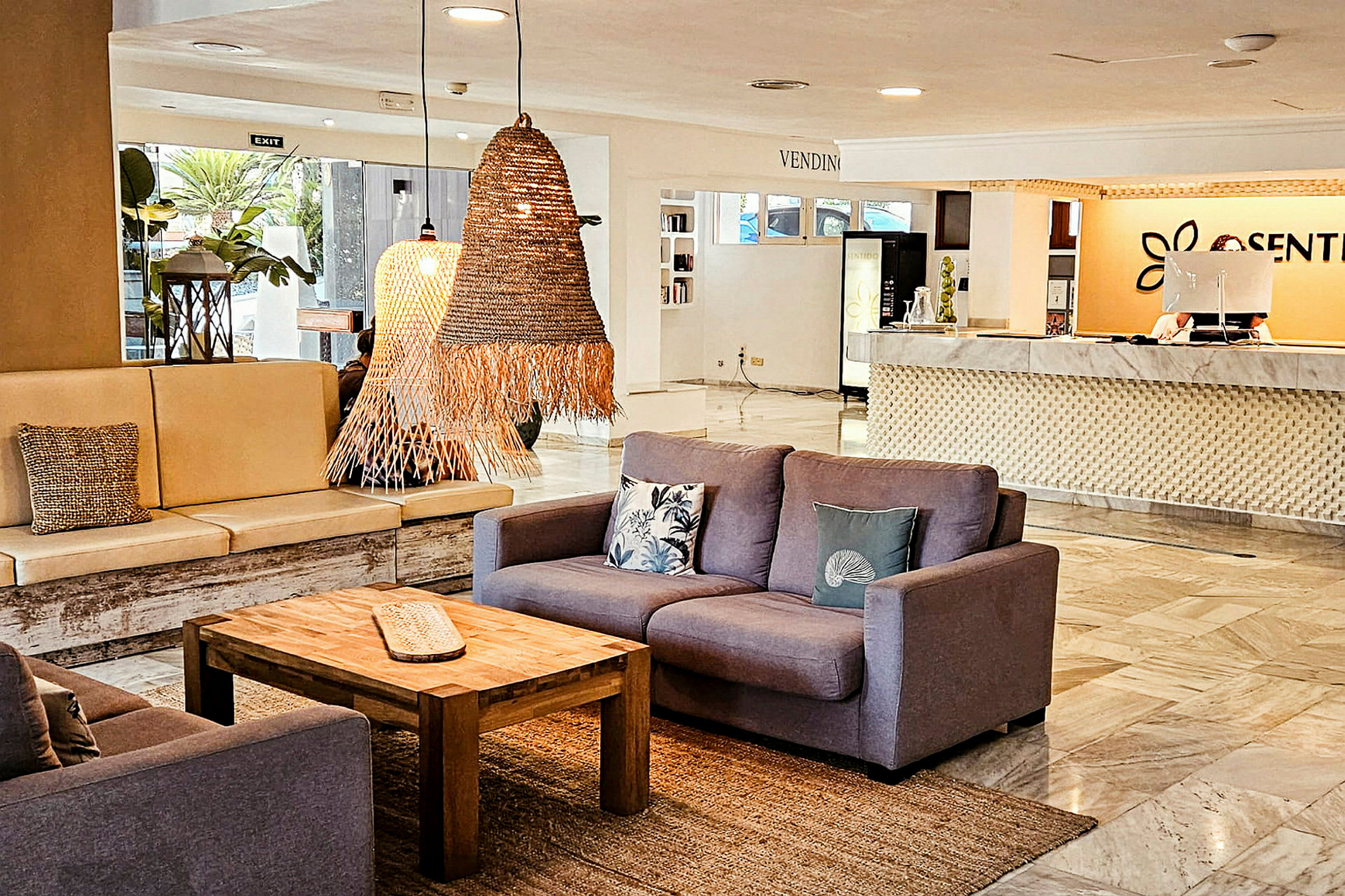 En hotellobby med siddegrupper, borde og reception. (AI-genereret tekst)