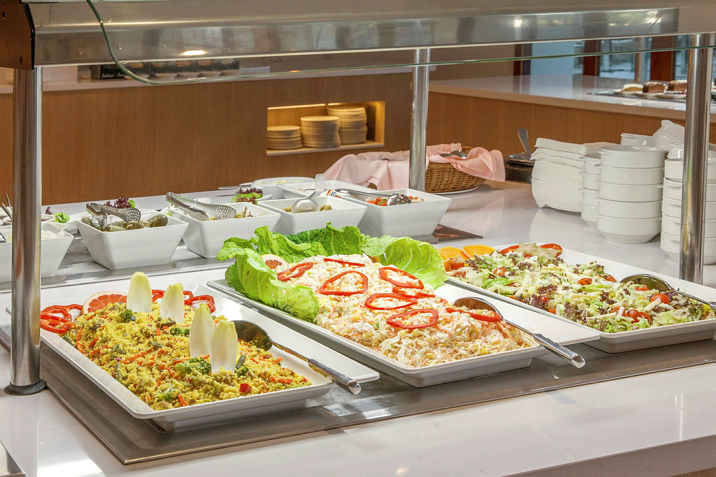 Buffet med salater og kolde retter i forskellige serveringsfade. (AI-genereret tekst)