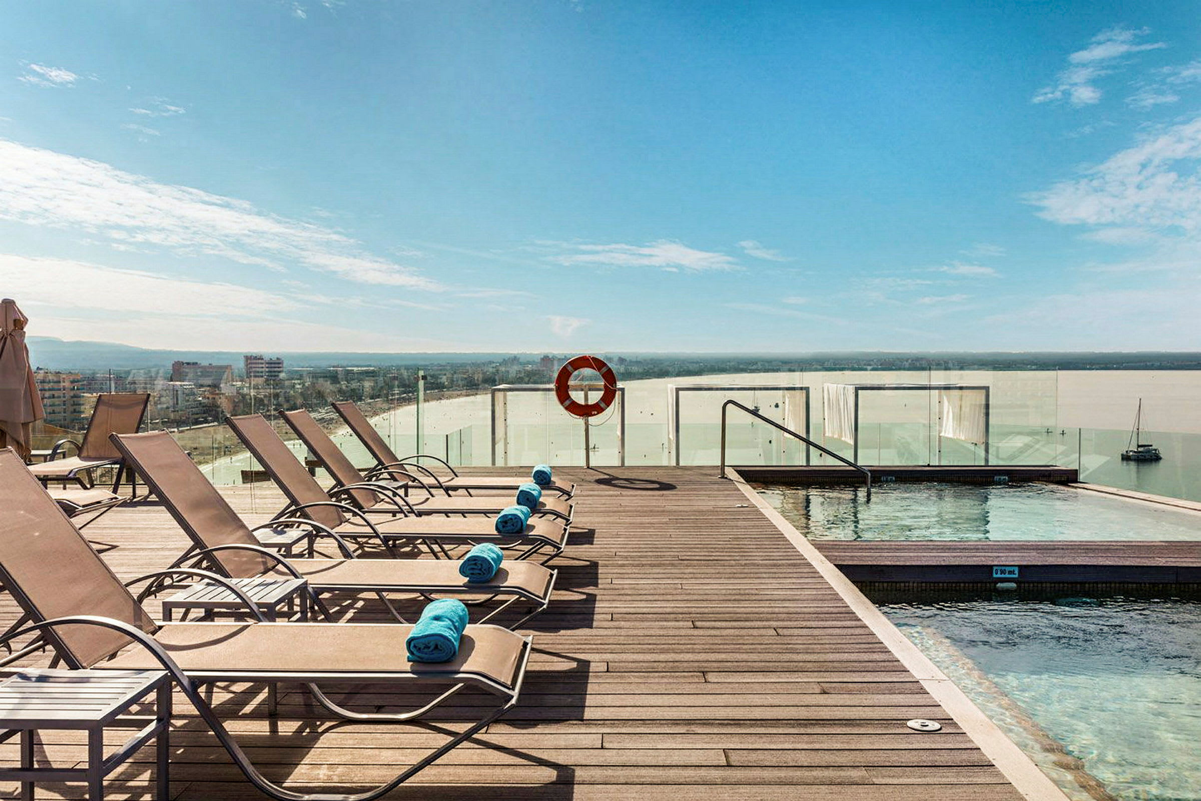 Solsenge ved en pool med udsigt til havet. (AI-genereret tekst)