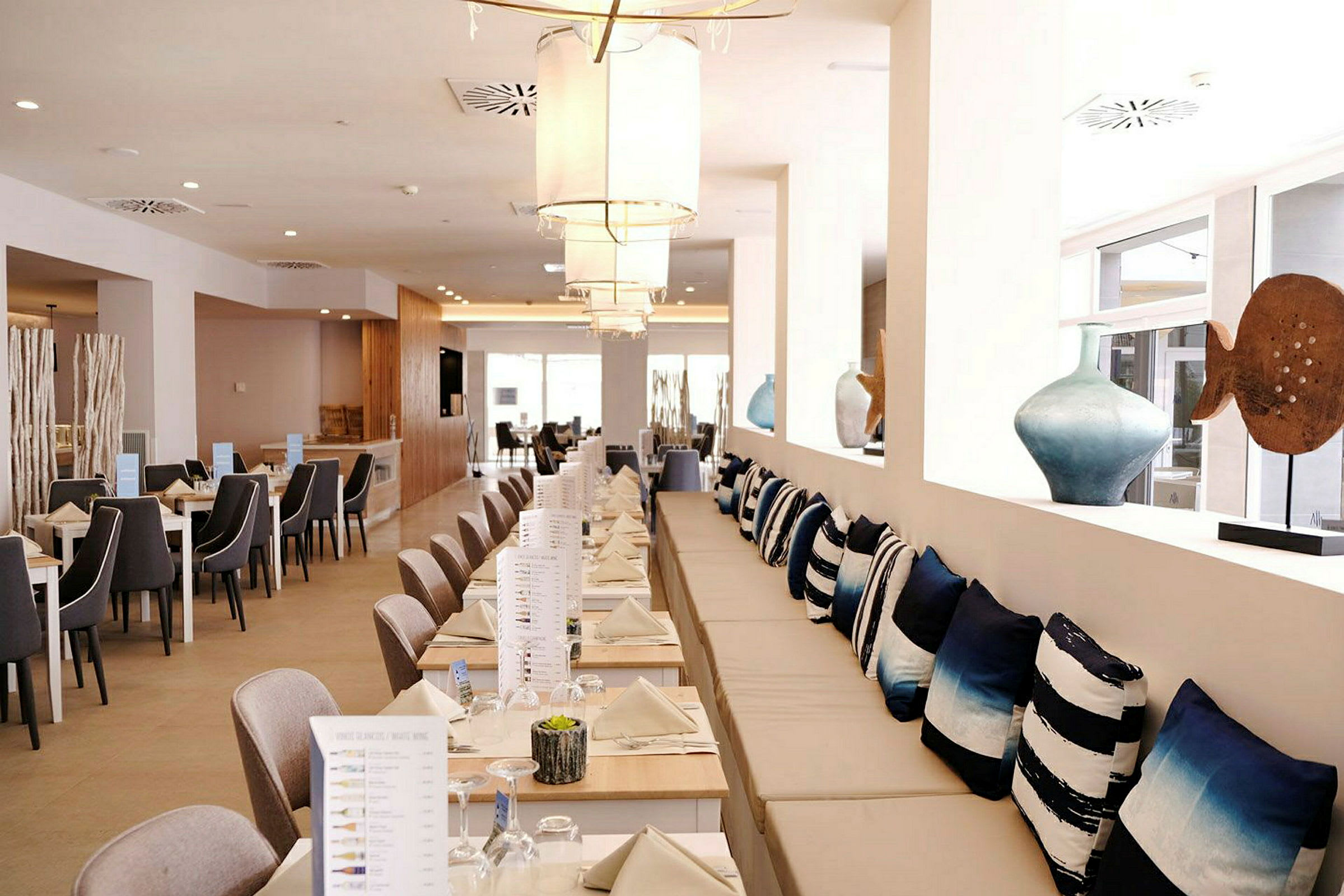 Restaurant med dækkede borde og dekorative puder. (AI-genereret tekst)