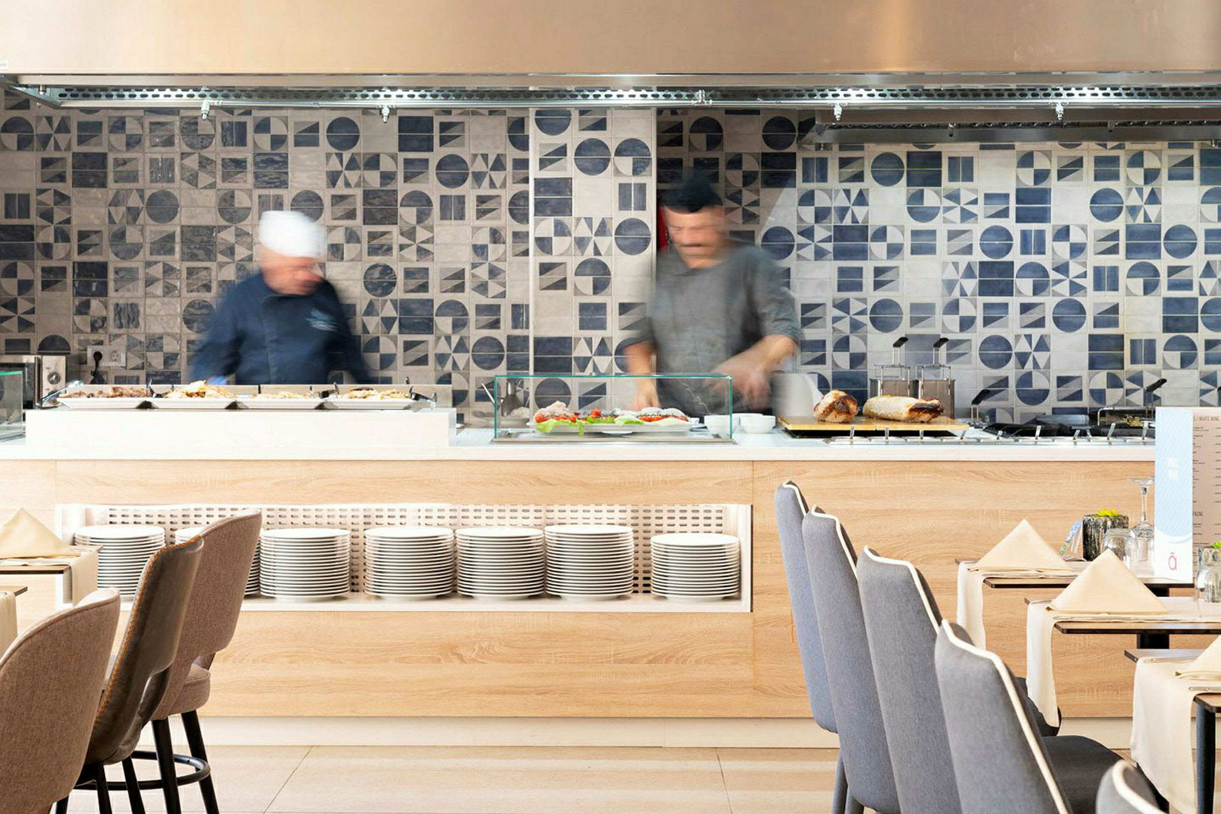 Buffetområde i restaurant med flisebelagte vægge og tallerkener. (AI-genereret tekst)