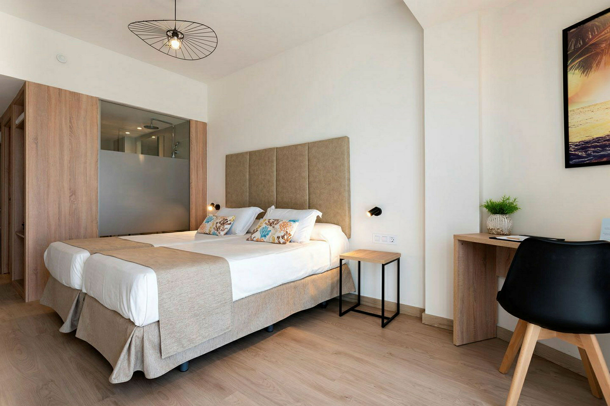 Et lyst hotelværelse med dobbeltseng og skrivebord. (AI-genereret tekst)