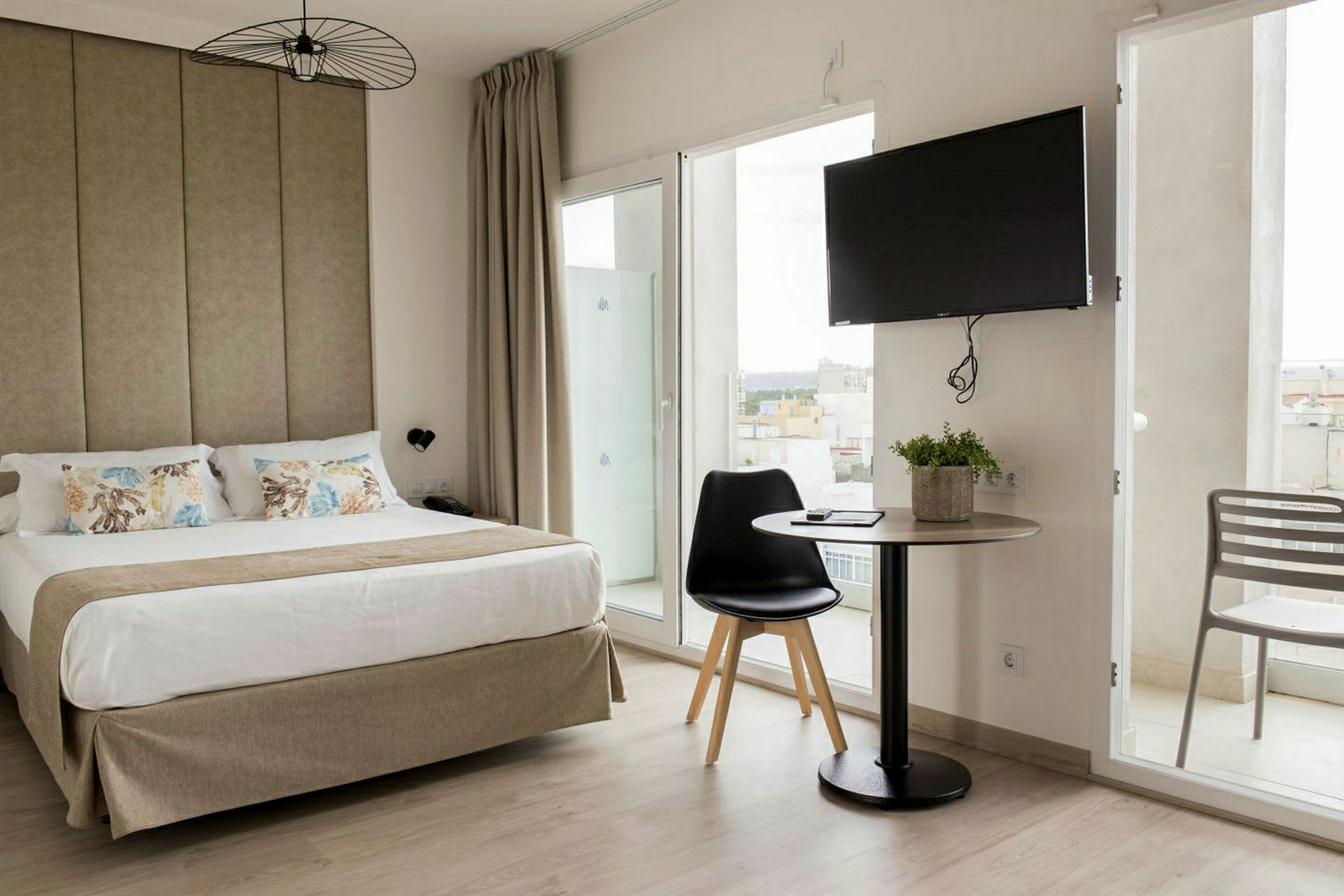 Hotelværelse med en dobbeltseng, et bord med stol og et tv på væggen. (AI-genereret tekst)