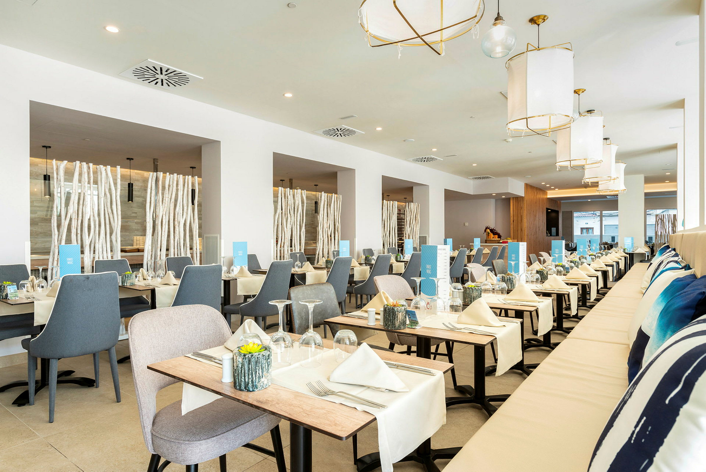 Lys og moderne restaurant med borde dækket med duge og servietter. (AI-genereret tekst)