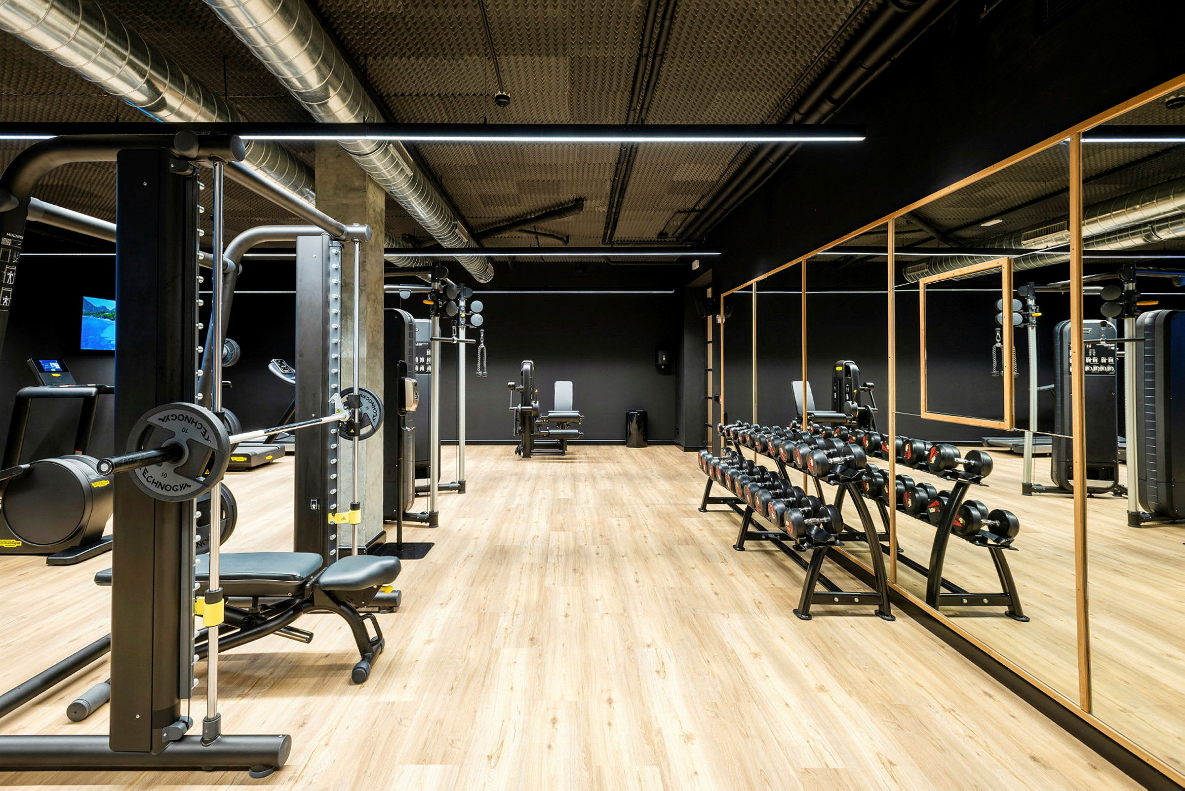 Billede af et fitnesscenter med træningsmaskiner og vægte. (AI-genereret tekst)