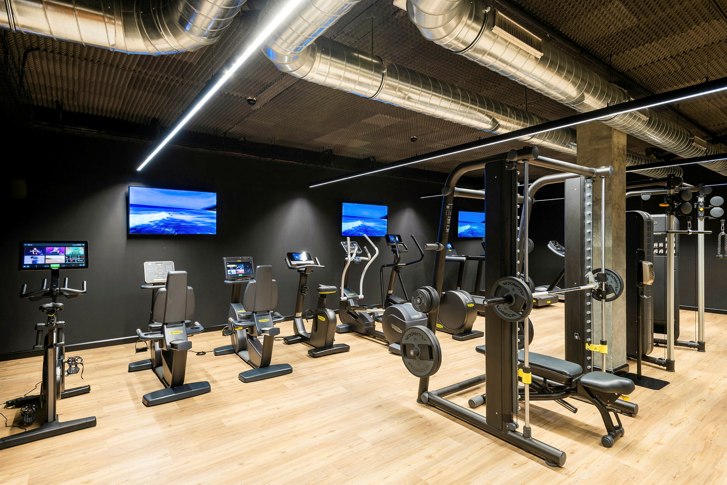 Et fitnesscenter med træningsudstyr såsom motionscykler og styrketræningsmaskiner. (AI-genereret tekst)