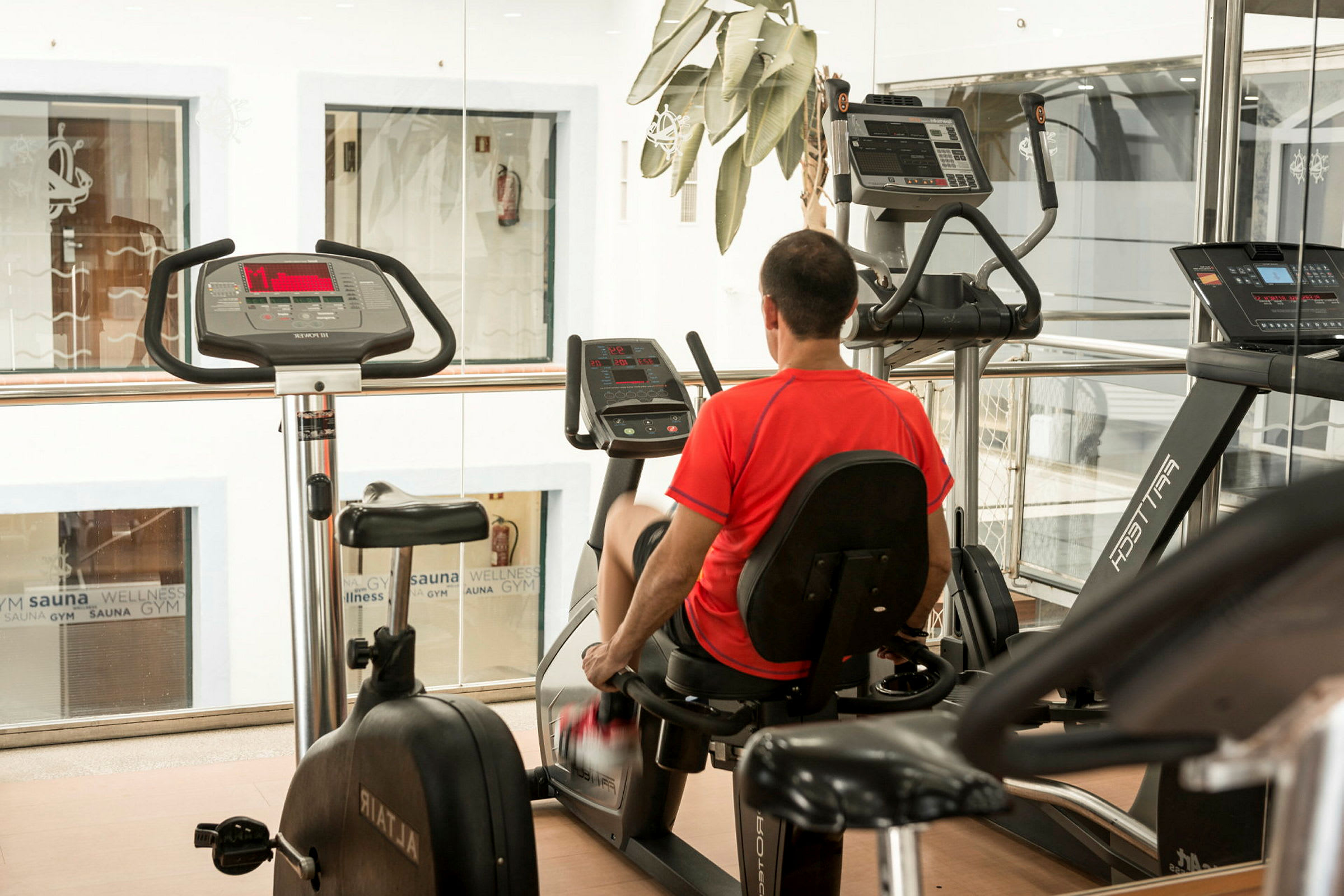 Mand, der bruger siddende kondicykel i et fitnesscenter. (AI-genereret tekst)