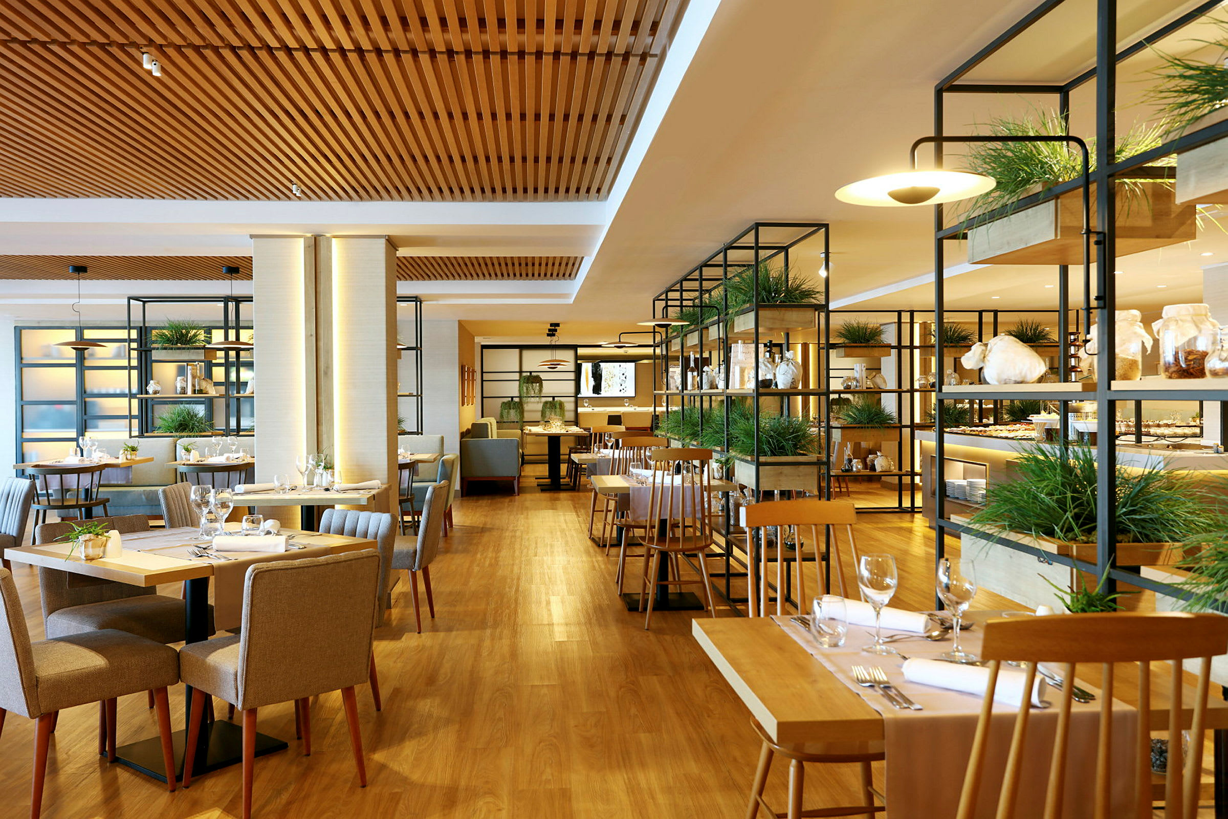Billede af en moderne restaurant med træborde og stole, planter og glashylder. (AI-genereret tekst)