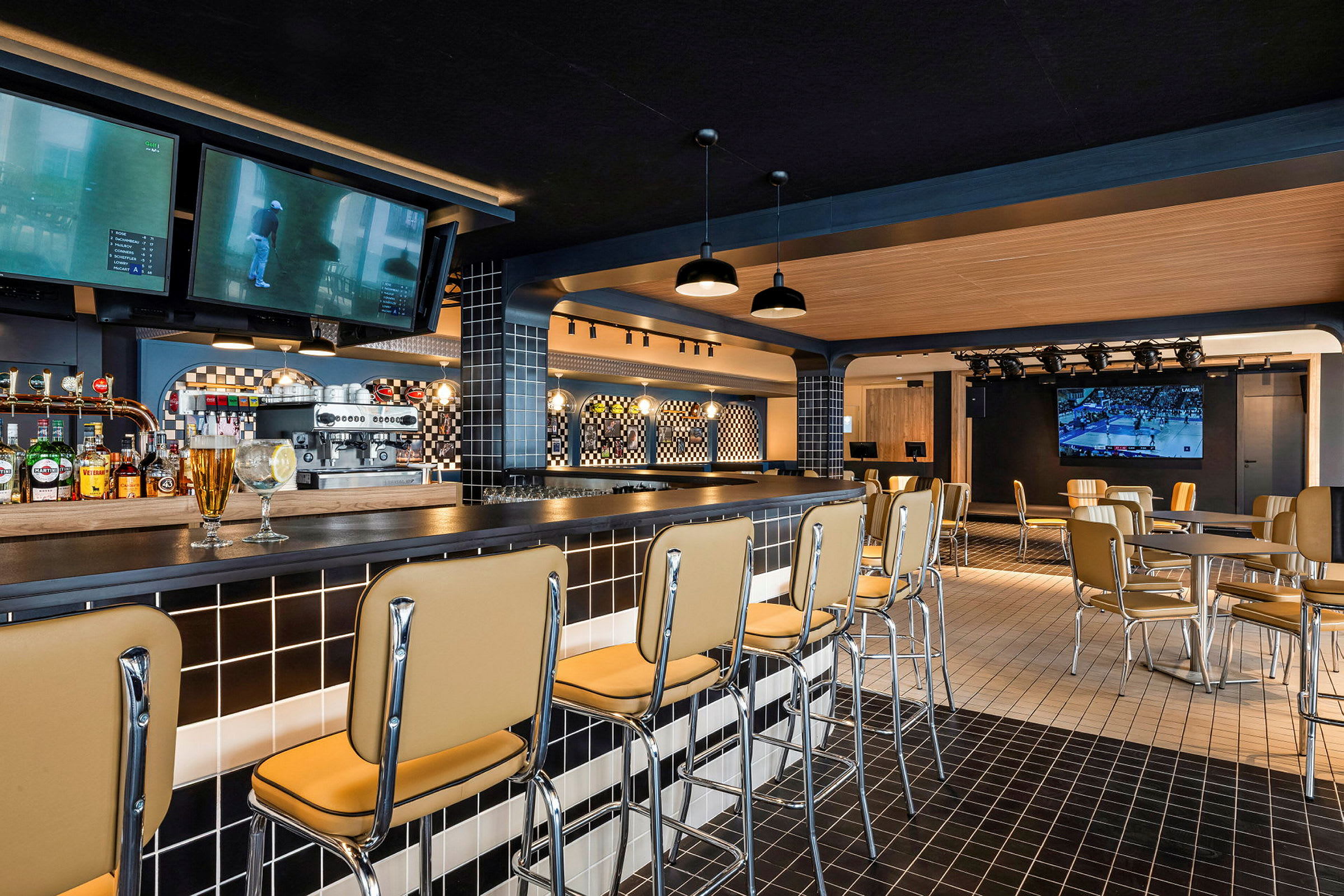 Indretning af en moderne bar med barstole, borde og et TV på væggen. (AI-genereret tekst)
