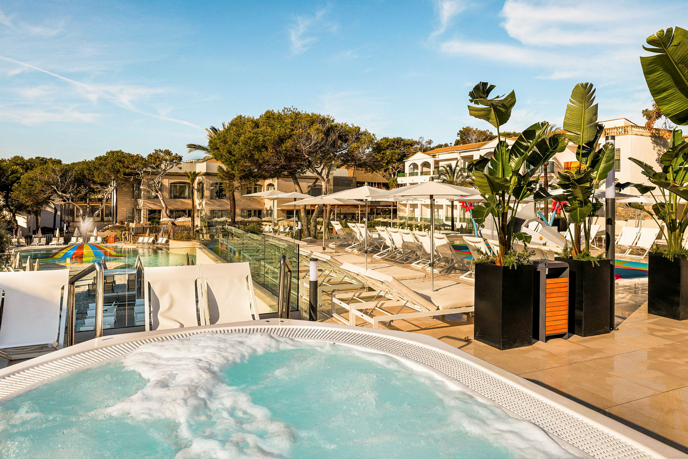 Udendørsområde med pool, liggestole og beplantning ved et feriehotel. (AI-genereret tekst)
