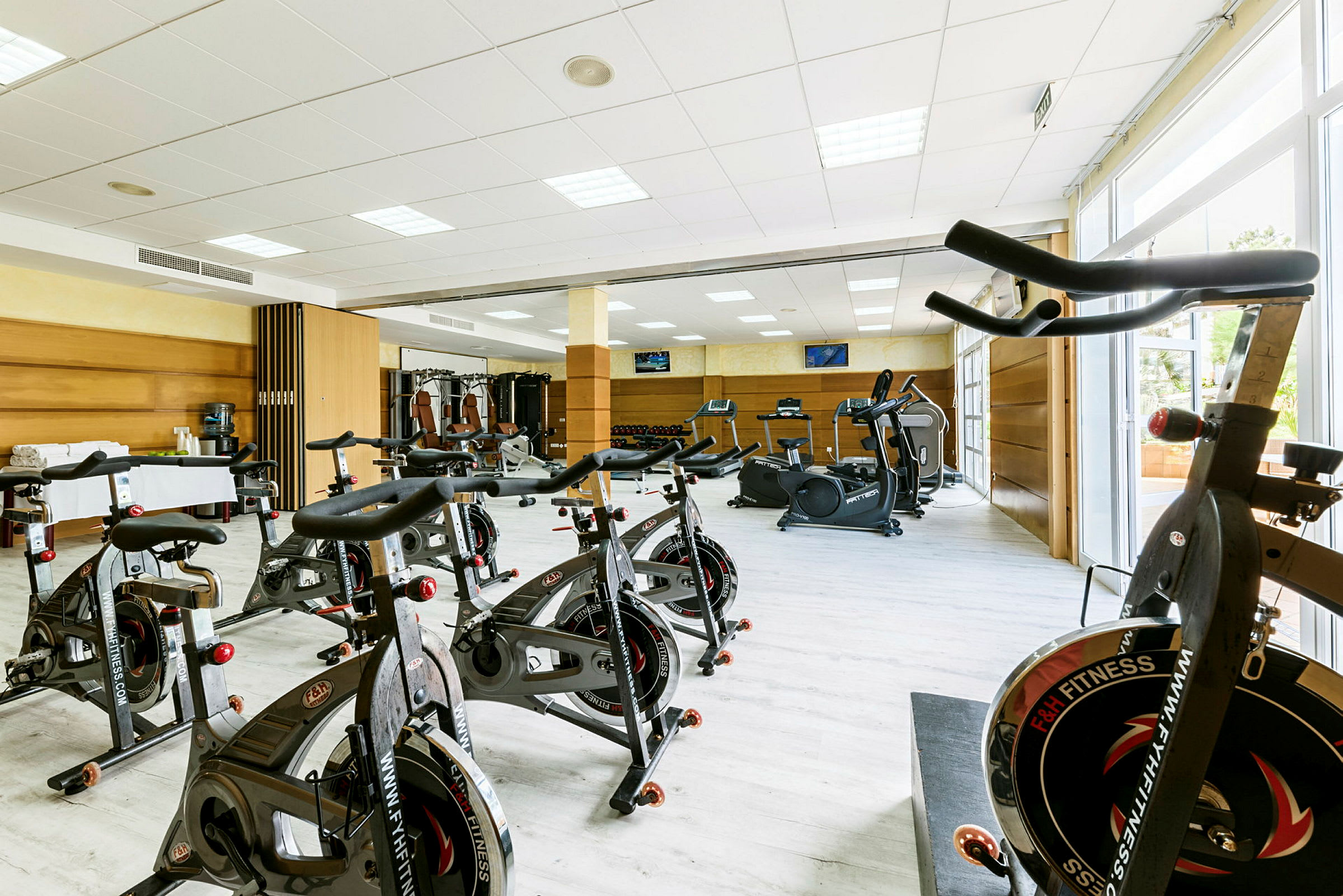 Et fitnesscenter med motionscykler og træningsmaskiner. (AI-genereret tekst)